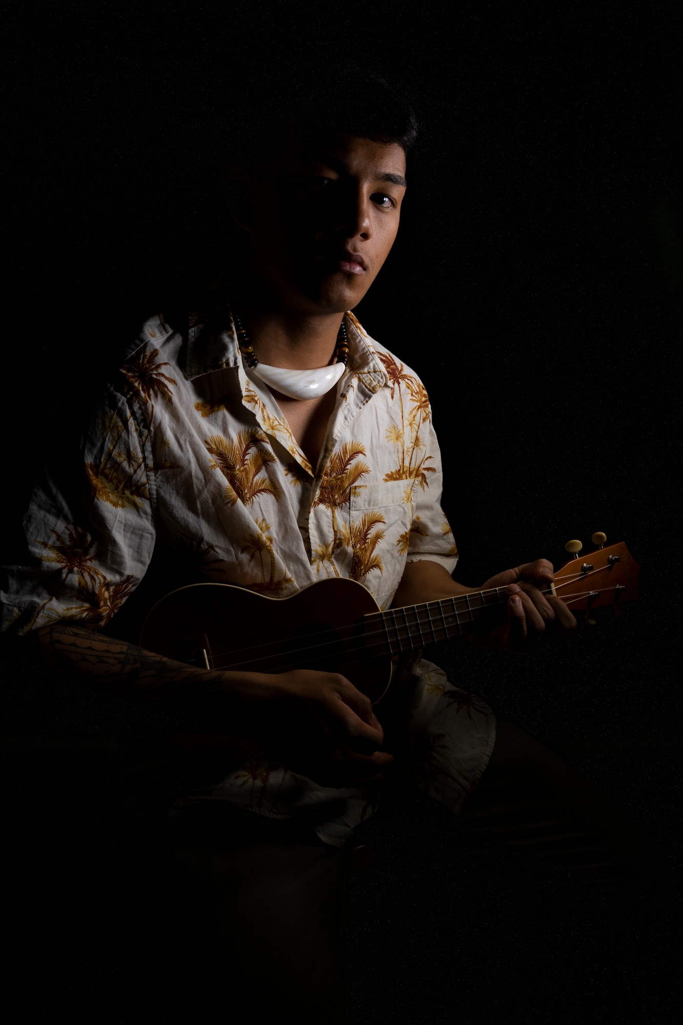 A young man playing the ukulele