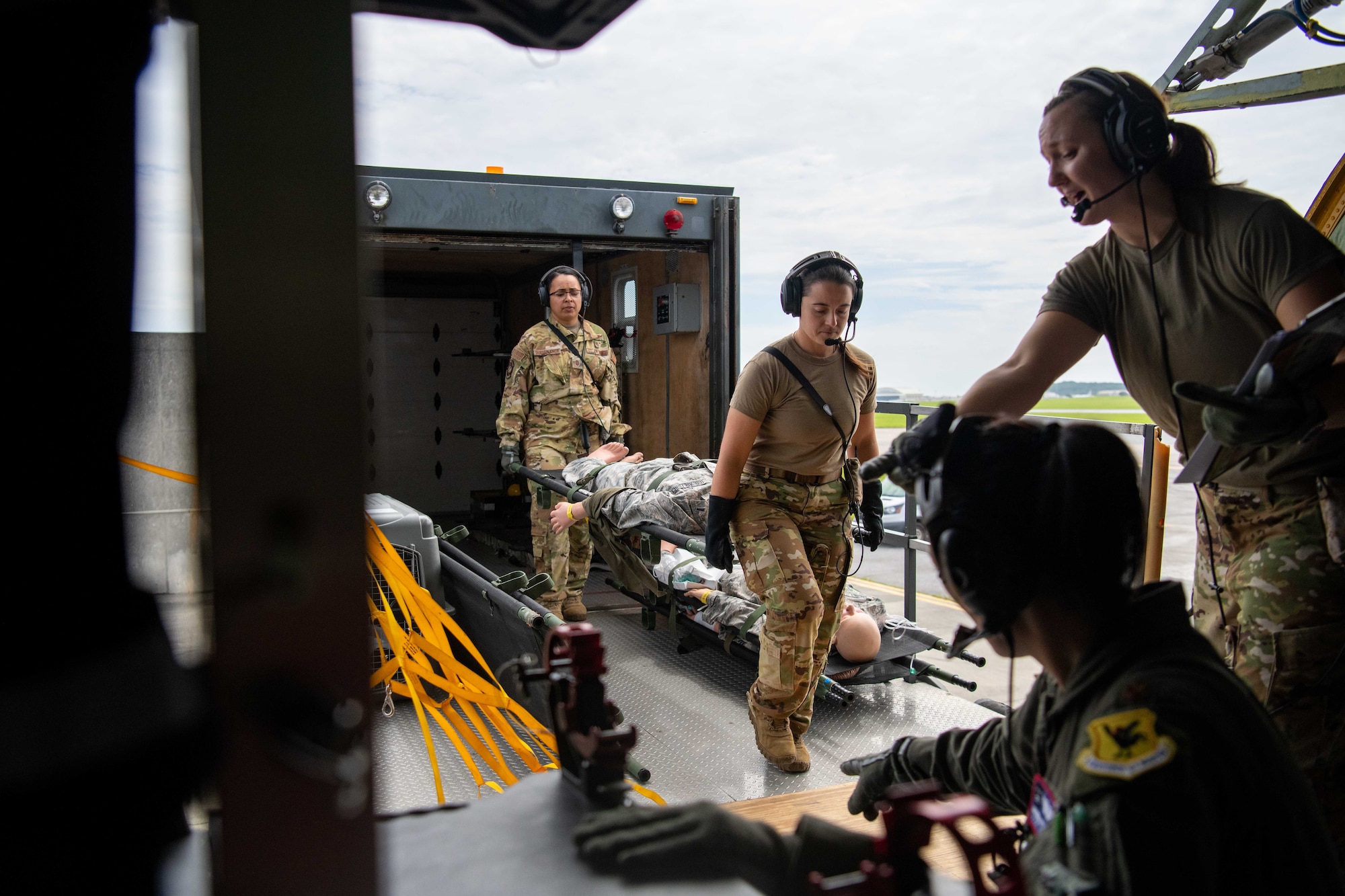 Airmen load simulated patients on a KC-135 Stratotanker.