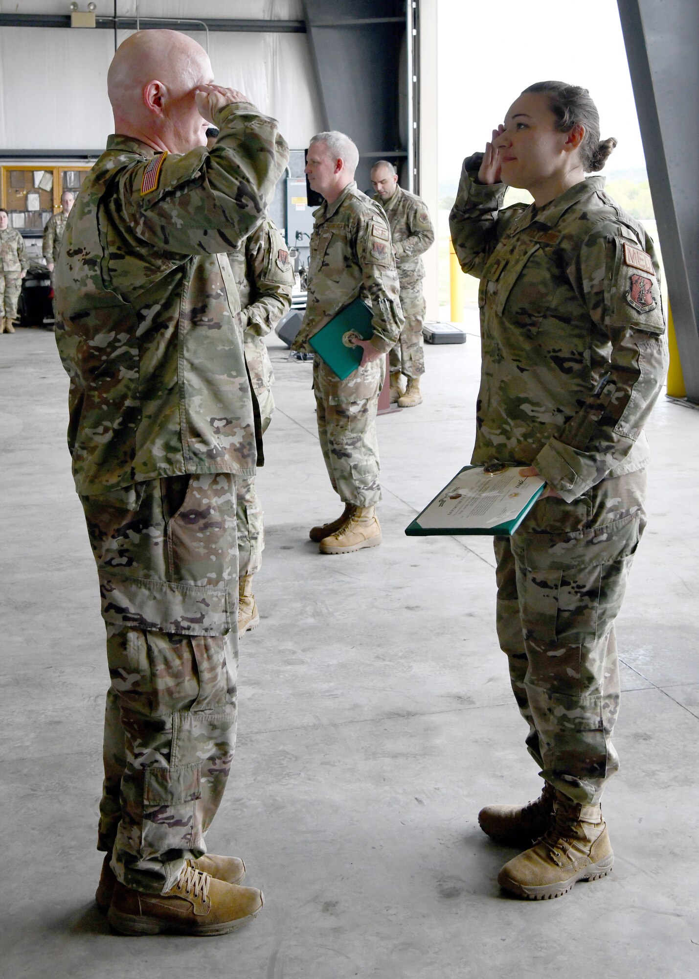 2nd Lt. Stephanie Dalton, 104th Medical Group aerospace medical technician, salutes U.S. Army Lt. Col. Patrick Donnelly, Task Force Powderhorn senior leader, during the TF Powderhorn awards ceremony at Barnes Air National Guard Base, Massachusetts, May 14, 2022.  Fifty four Barnestormers were awarded Army Achievement Medals for their outstanding performance during TF Powderhorn, an activation where members supported state medical facilities. (U.S. Air National Guard Photo by Senior Airman Camille Lienau)