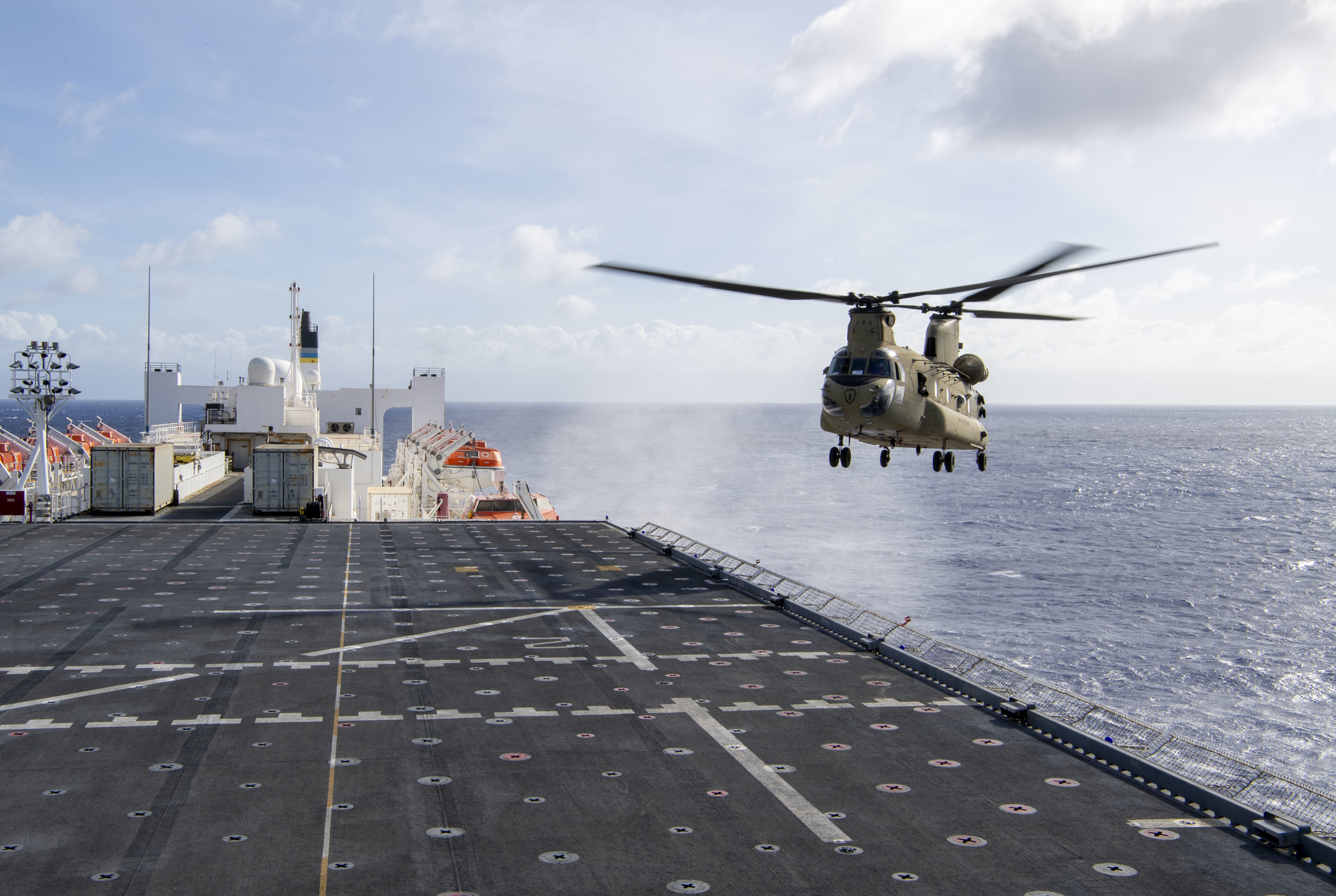 A CH-47 Chinook helicopter prepares to land on the flight deck of Military Sealift Command hospital ship USNS Mercy (T-AH 19) while underway for Pacific Partnership 2022, May 11, 2022.