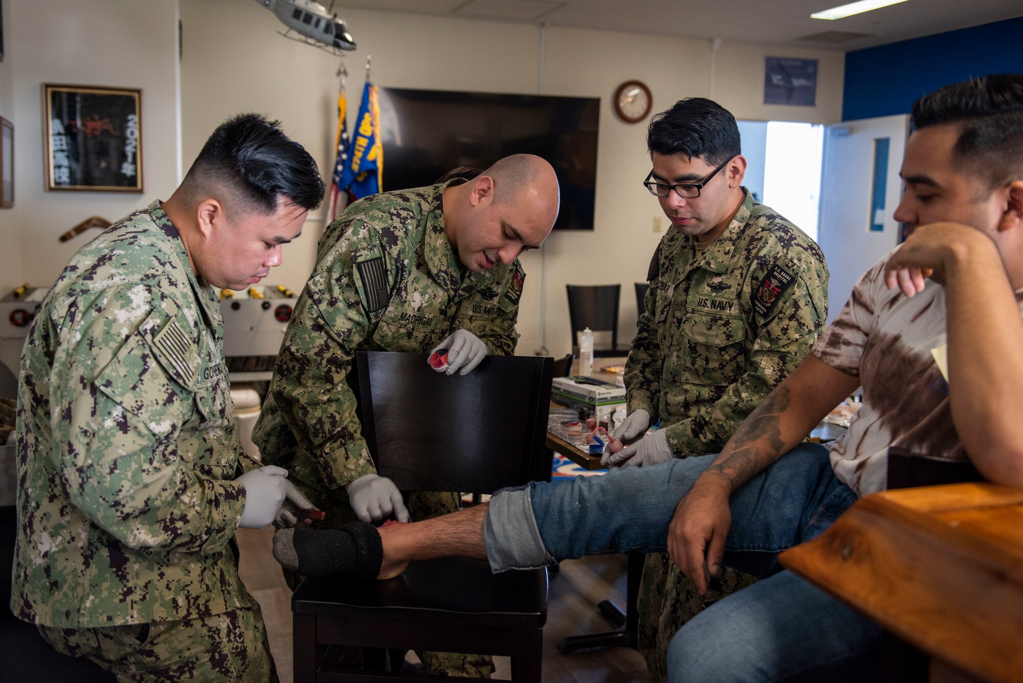 Navy sailors apply makeup to a mock wound