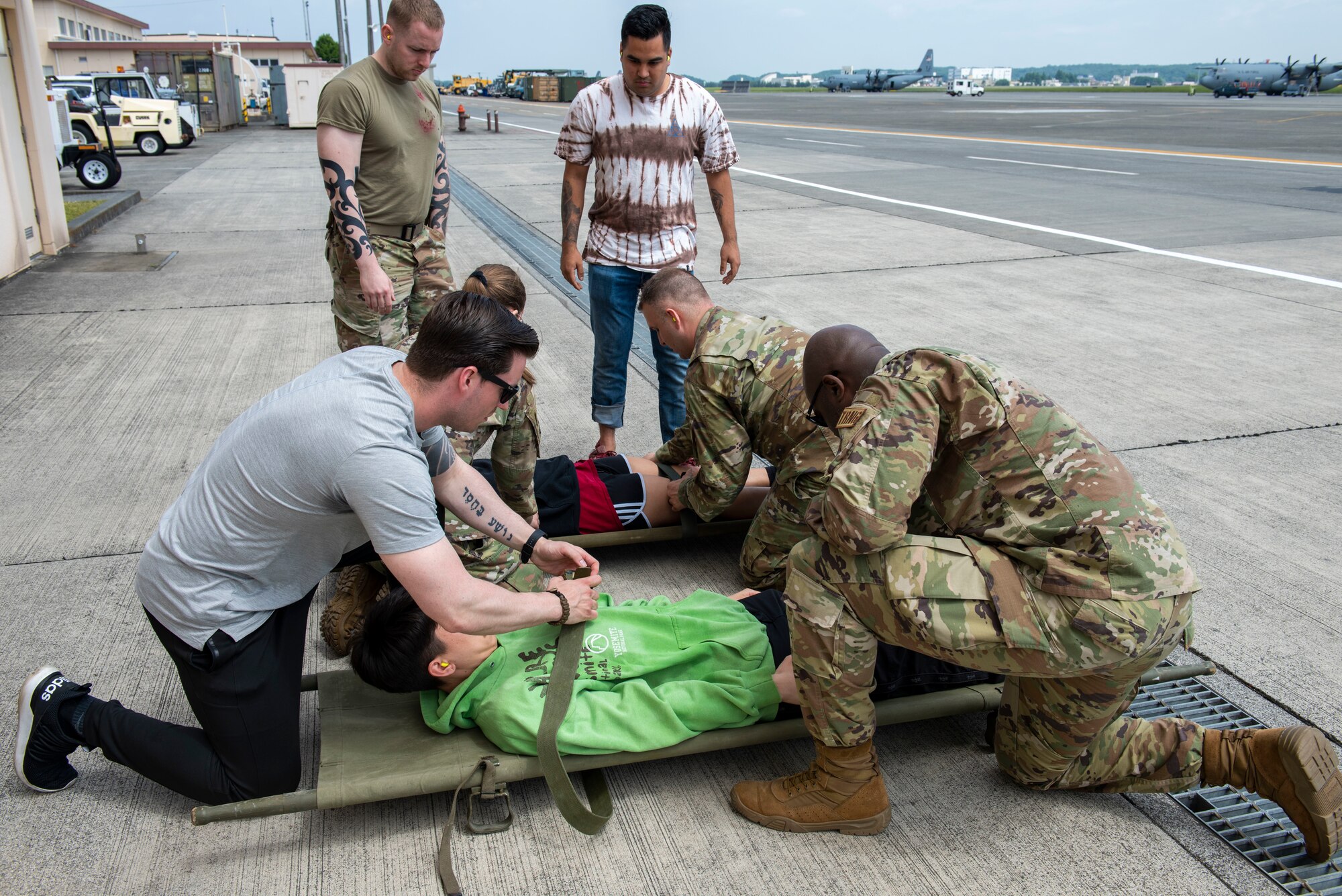 Airmen strap down volunteer mock patients to a litter