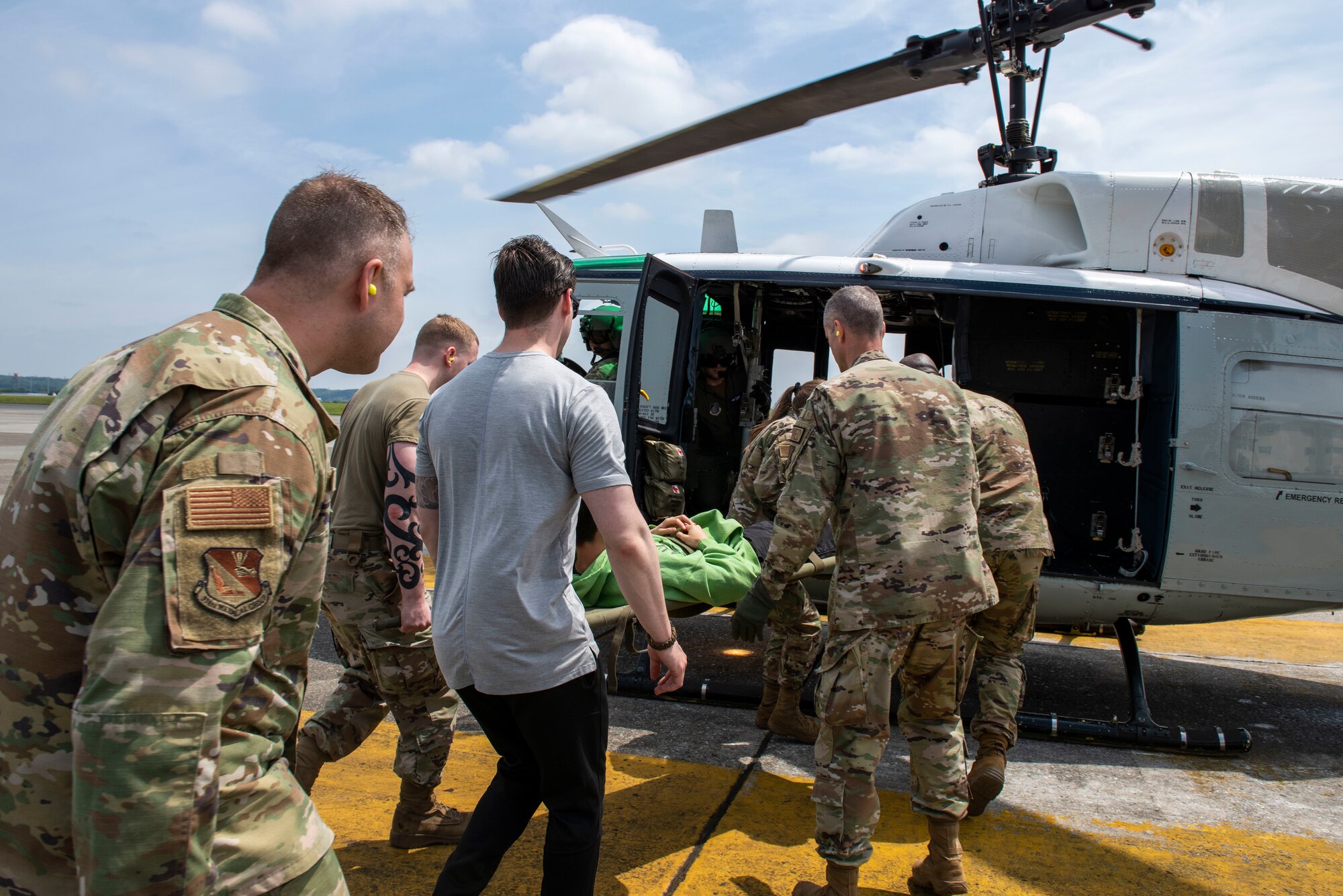 Airmen transport mock casualties to a helicopter