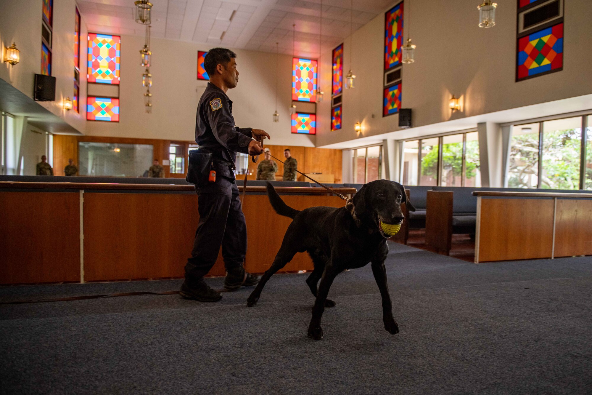 A dog handler and his dog search for simulated bombs throughout a church