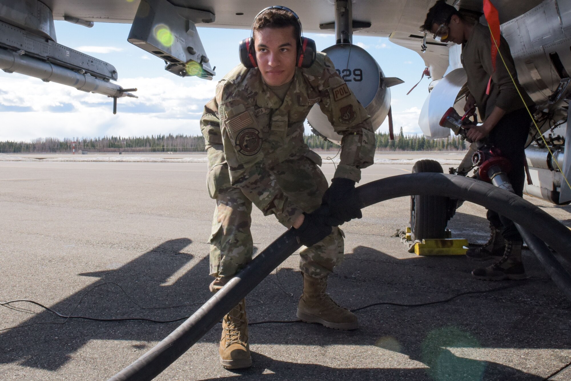 U.S. Air Force Airman Santiago Pompa Rivera, 354th Logistic Readiness Squadron fuels distribution apprentice, pulls a fuel hose during an F-16 Fighting Falcon refuel in support of RED FLAG-Alaska 22-1 at Eielson Air Force Base, May 4, 2022.