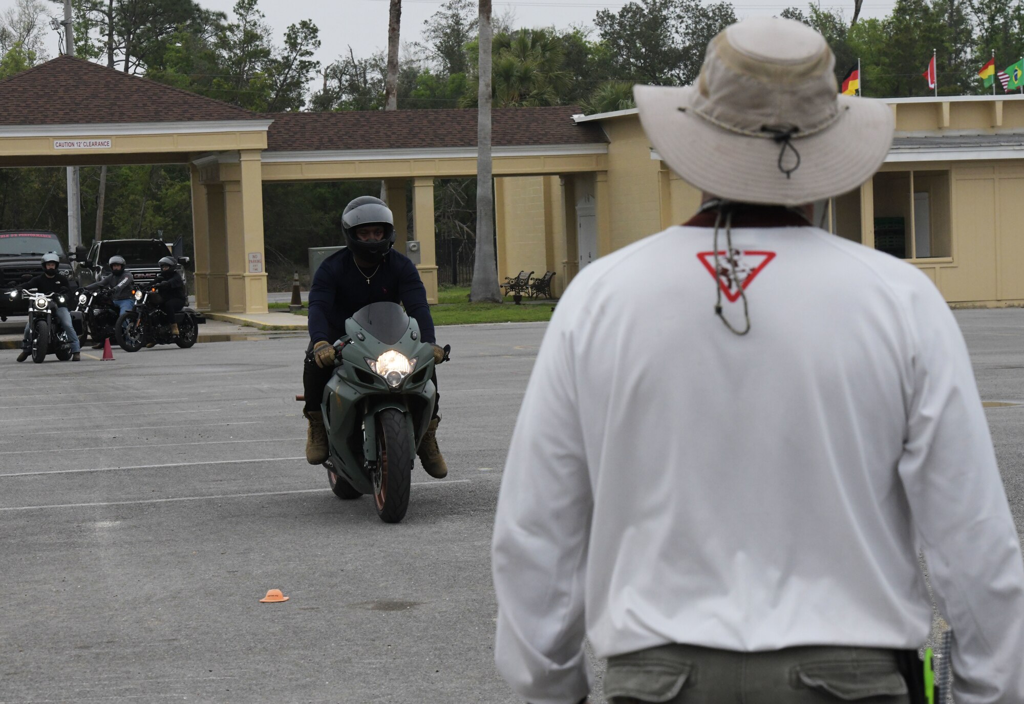 U.S. Air Force Senior Airman Ordavion McChristian, 325th Security Forces Squadron alarm monitor, approaches a motorcycle training coach to practice stopping procedures in Panama City, Florida, April 6, 2022.