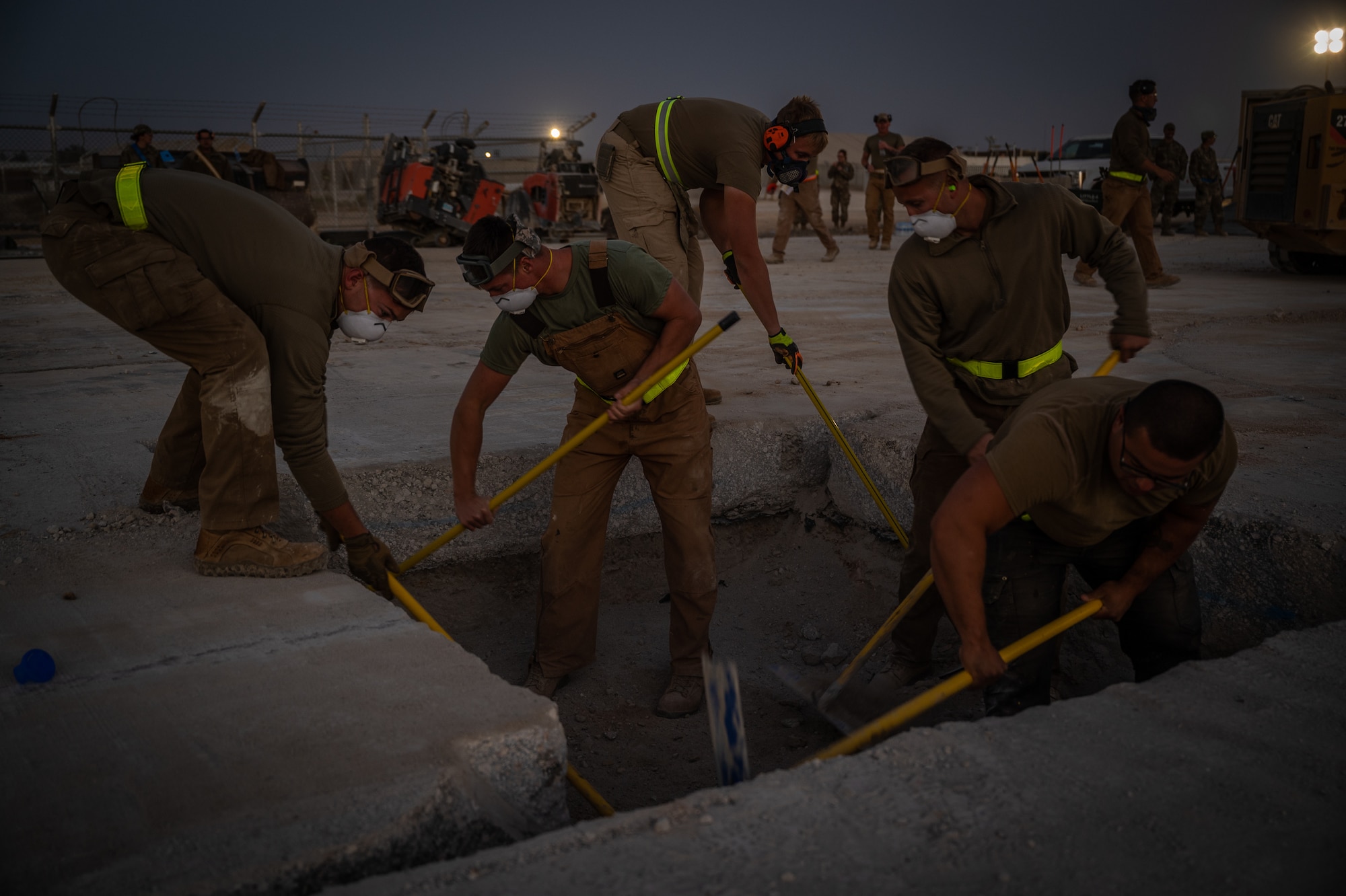 332d Expeditionary Civil Engineer Squadron Airmen measure the base of a crater to confirm it is at proper elevation before backfill material is placed within it during a rapid airfield damage recovery exercise at an undisclosed location in Southwest Asia, May 12, 2022. RADR exercises test the ability of the 332d ECES to rapidly repair runways and runway support structures to recover and resume airfield operations after it has experienced significant damage. (U.S. Air Force photo by Master Sgt. Christopher Parr)