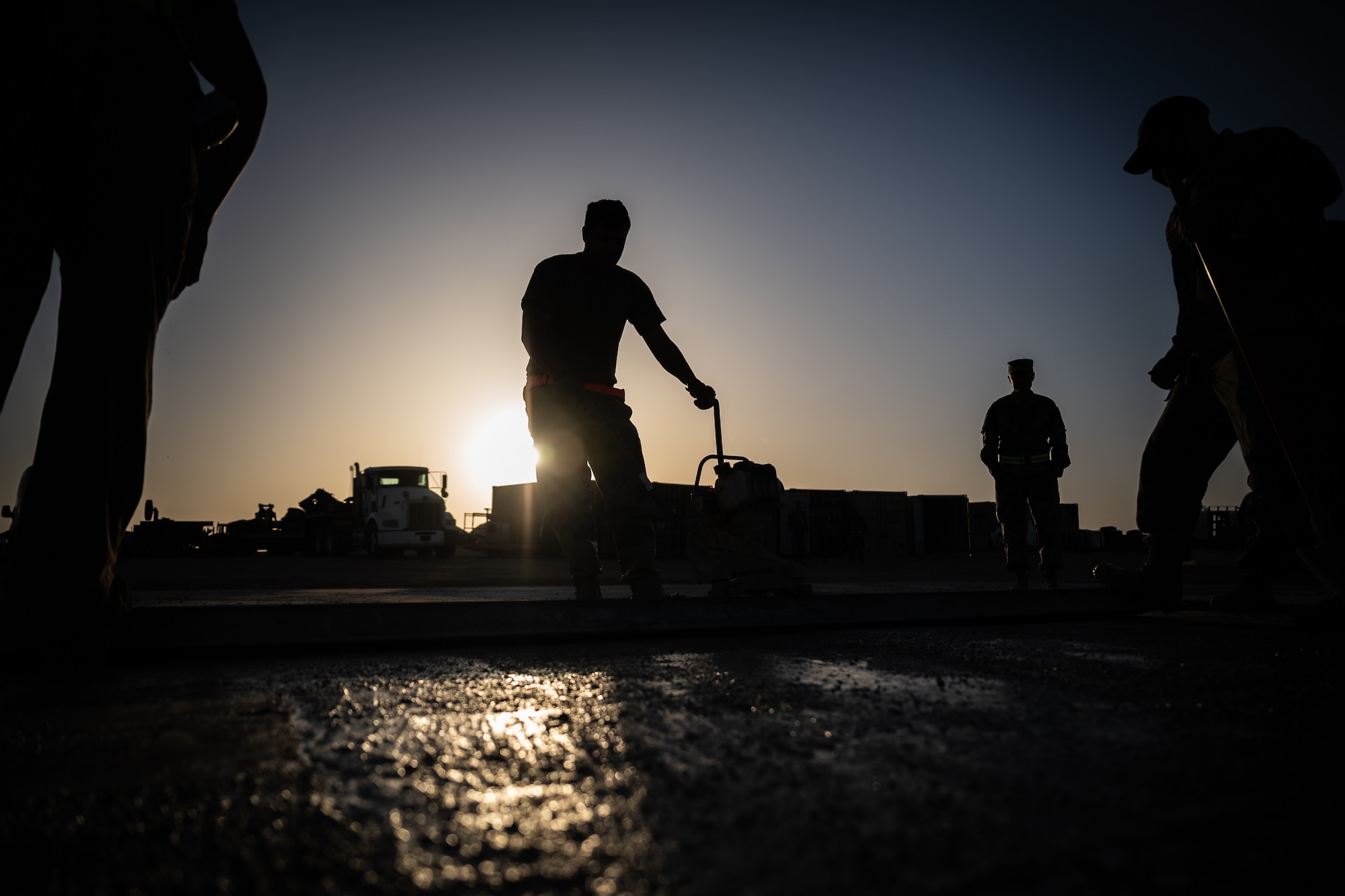 Senior Airman Alexander Curtiss, 332d Expeditionary Civil Engineer Squadron structural specialist journeyman, uses a power concrete screed to confirm a level surface during a rapid airfield damage recovery exercise at an undisclosed location in Southwest Asia, May 12, 2022. RADR exercises test the ability of the 332d ECES to rapidly repair runways and runway support structures to recover and resume airfield operations after it has experienced significant damage. (U.S. Air Force photo by Master Sgt. Christopher Parr)