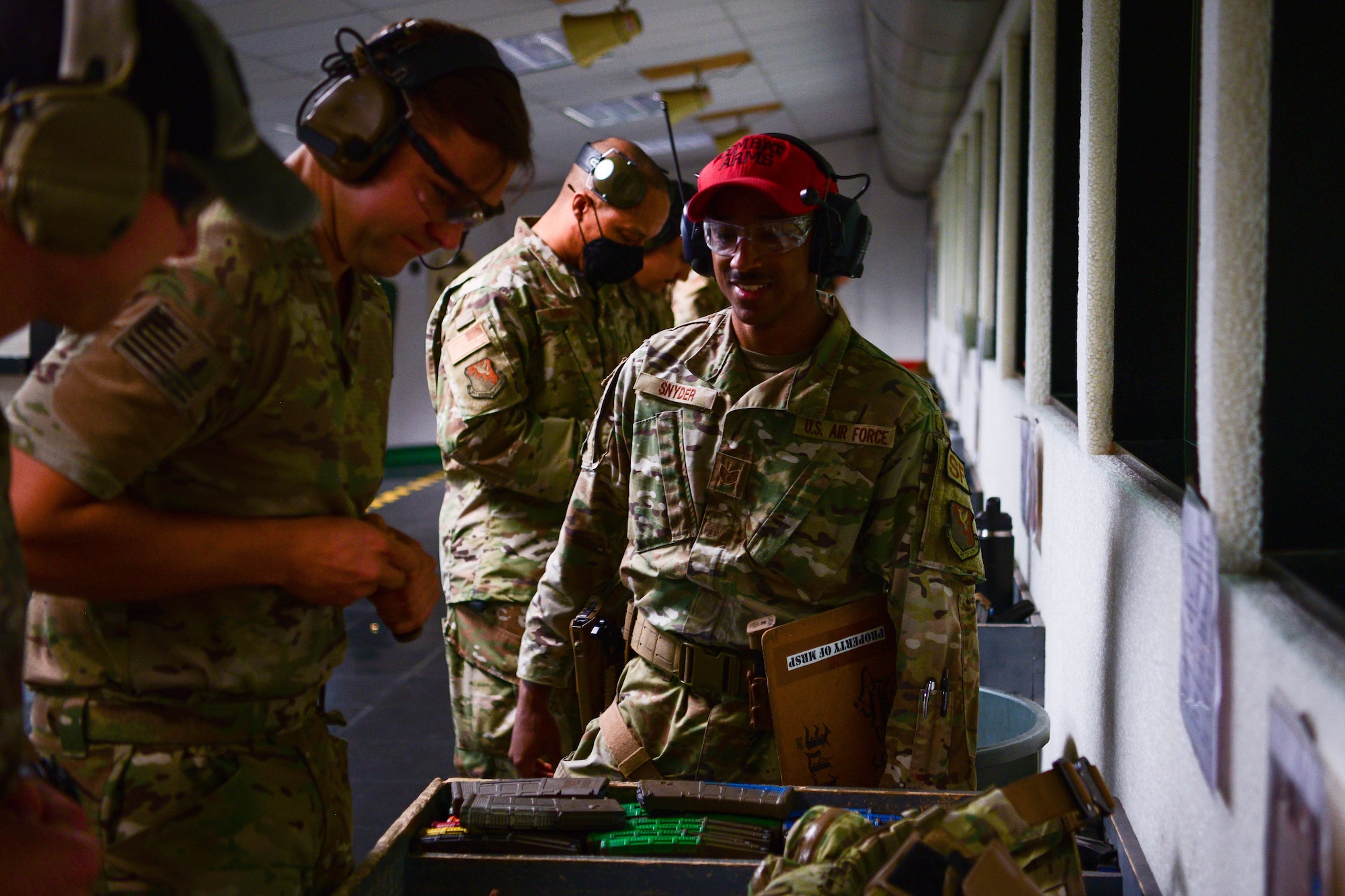 U.S. Air Force Staff Sgt. Jalen Snyder, 31st Security Forces Squadron combat arms instructor, right, supervises individuals loading bullets into a magazine during the 2022 Excellence in Competition Pistol match at Aviano Air Base, Italy, May 17, 2022. Each participant fired 30 rounds at a target while being timed. Police Week pays tribute to the local, state, and federal police officers who have died or who been disabled in the line of duty. (U.S Air Force photo by Senior Airman Brooke Moeder)
