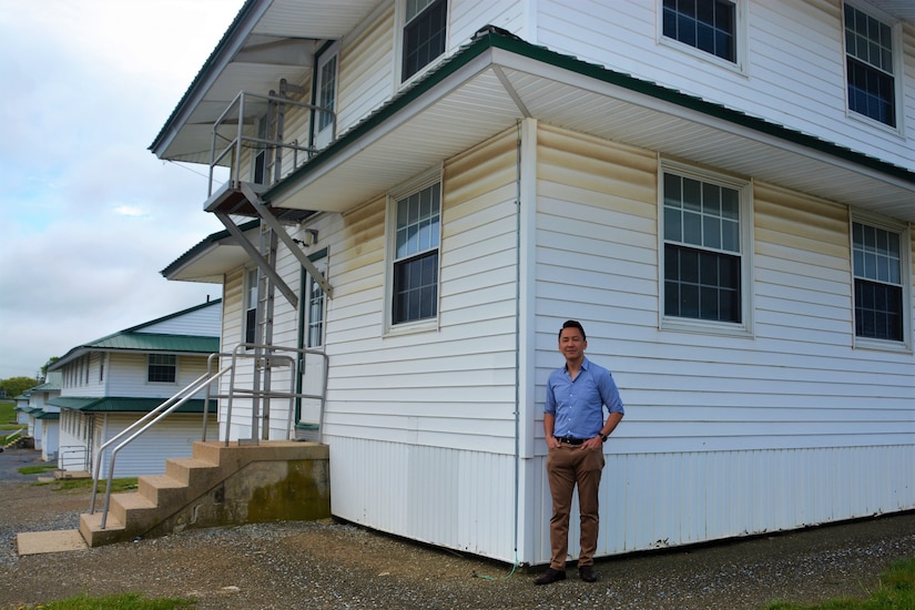 Viet Nguyen, a former Vietnamese refugee who was housed at Fort Indiantown Gap with his family for several months in 1975, stands outside a barracks building at Fort Indiantown Gap, Pa., on May 13, 2022. The building is similar to the one he and his family stayed in after fleeing Vietnam.