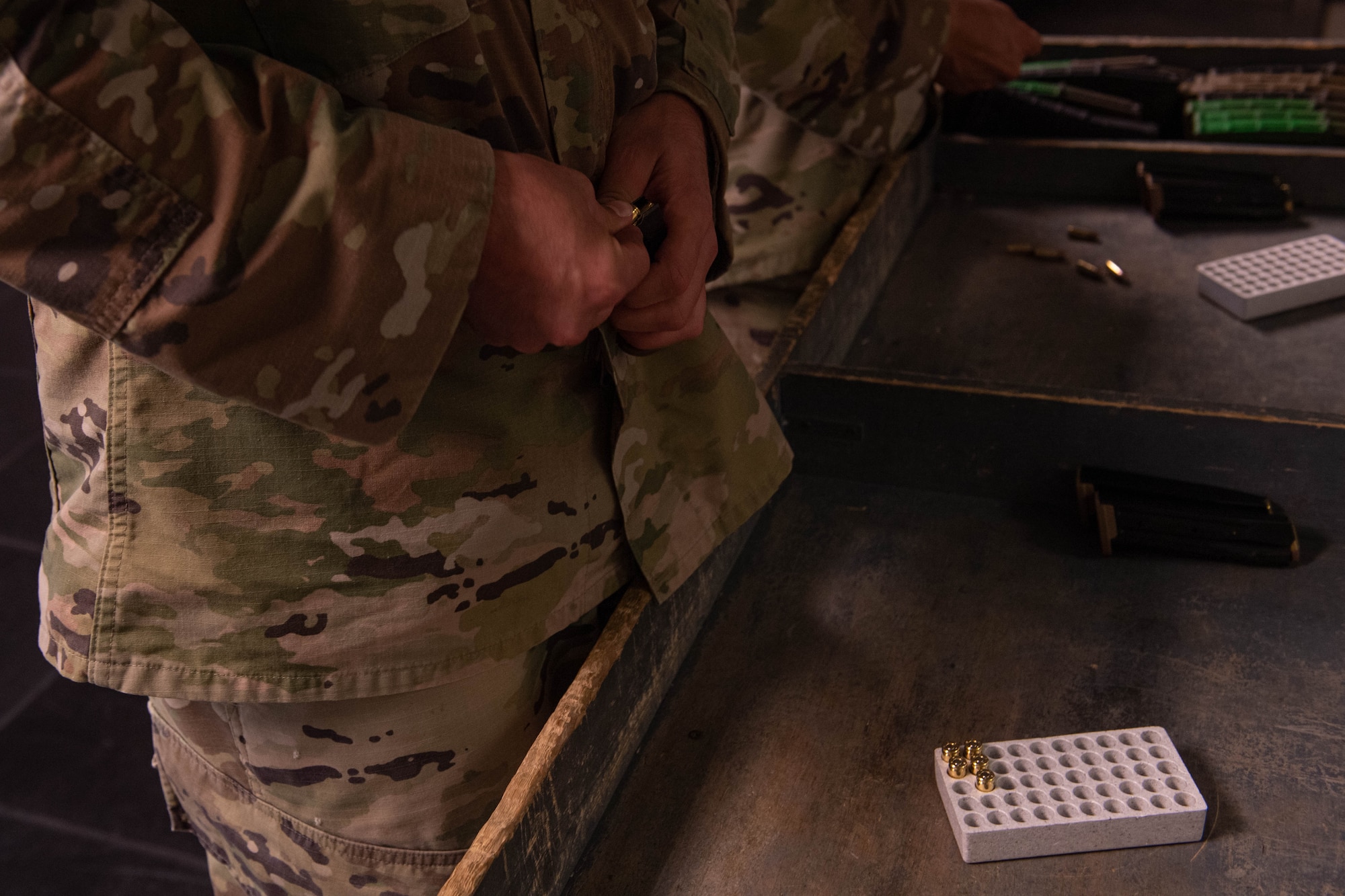 A U.S. Air Force Airman from the 31st Fighter Wing loads bullets during the 2022 Excellence in Competition Pistol match hosted by Combat Arms at Aviano Air Base, Italy, May 17, 2022. Airmen were allotted a total of 30 rounds to fire during three timed scenarios modeled after Security Forces training in honor of Police Week. Police Week has been held annually since 1962, after President Kennedy designated the week of May 15 in remembrance of officers who have died in the line of duty. (U.S. Air Force photo by Airman 1st Class Thomas Calopedis)
