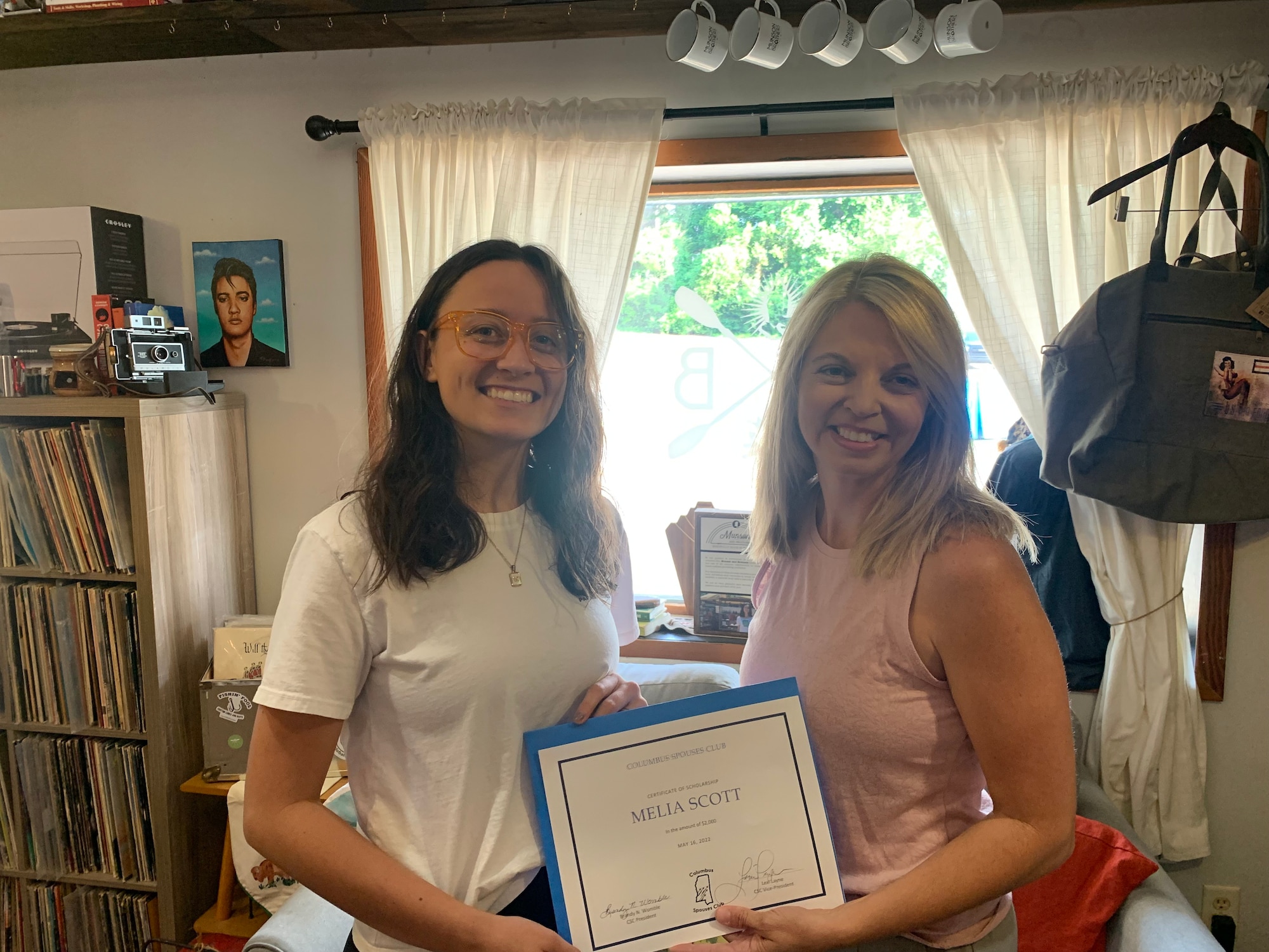 Melia Scott, 50th Flying Training Squadron spouse is presented a $2,000 scholarship by Brandy Womble, Columbus Spouses Club president, for leadership qualities and community involvement. The CSC runs the base thrift shop, where they raise the majority of the money used for community needs. (Courtesy photo)