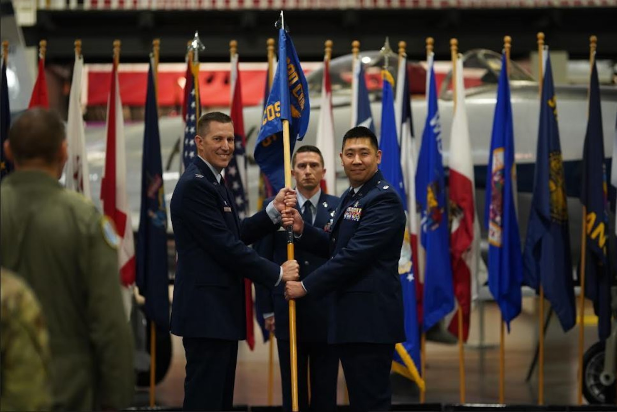 U.S. Air Force Col. Billy Pope, passes the newly activated 692nd Cyberspace Operations Squadron's guidon to U.S. Air Force Lt. Col. James Cho, 692nd COS commander during the activation ceremony, April 20, 2022 at Elgin Air Force Base, Florida.