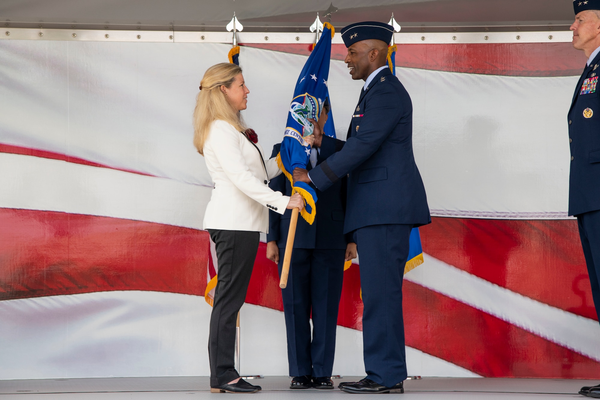 Maj. Gen. Troy Dunn receives the Air Force's Personnel Center guidon from Gwendolyn DeFilippi, acting Deputy Chief of Staff for Manpower, Personnel and Services, Headquarters Air Force. Dunn assumed command in a ceremony at Joint Base San Antonio-Randolph, Texas, May 18, 2022. (U.S. Air Force photo by Sean Worrell)