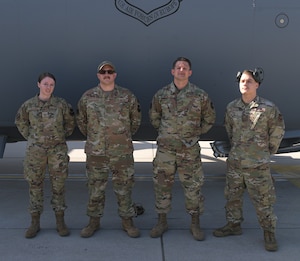 Four Airman stand in front of an aircraft