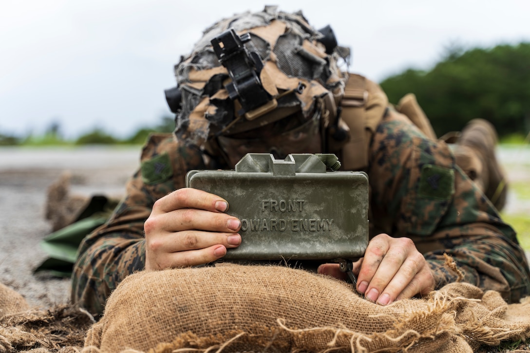 A U.S. Marine with 3rd Battalion, 2nd Marines places an M18 Claymore mine during a live fire range in Okinawa, Japan, May 12, 2022. This range integrates raiding and demolition tactics to enhance the Marines' ability to breach obstructions and perform combat operations in an urban environment. 3/2 is forward-deployed in the Indo-Pacific under 4th Marine Regiment, 3rd Marine Division.