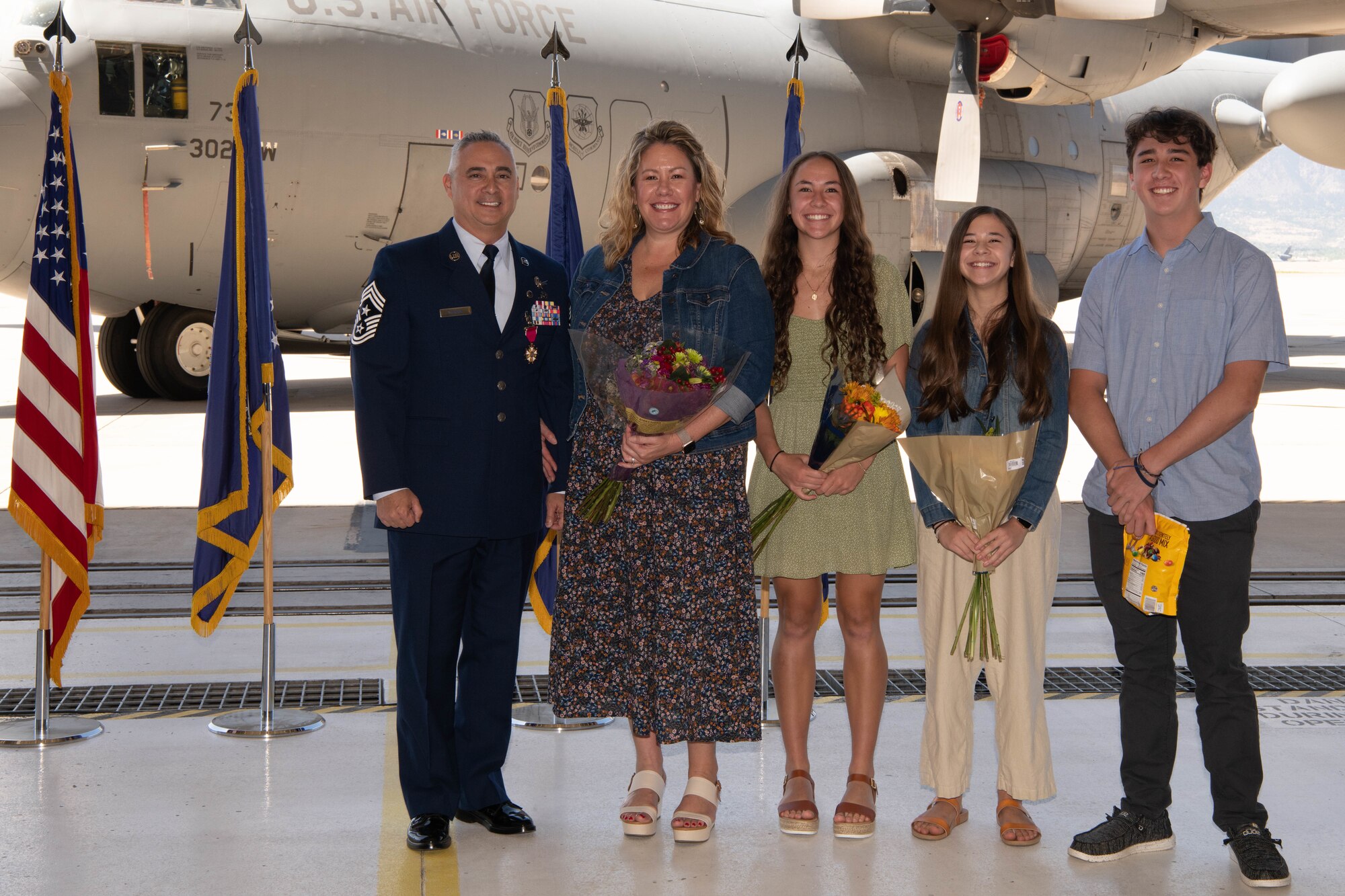 Chief Master Sgt. Kahn Scalise, 302nd Airlift Wing command chief, poses for a photo with his family during his retirement ceremony.