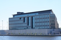 A massive cyber security building located next to water.