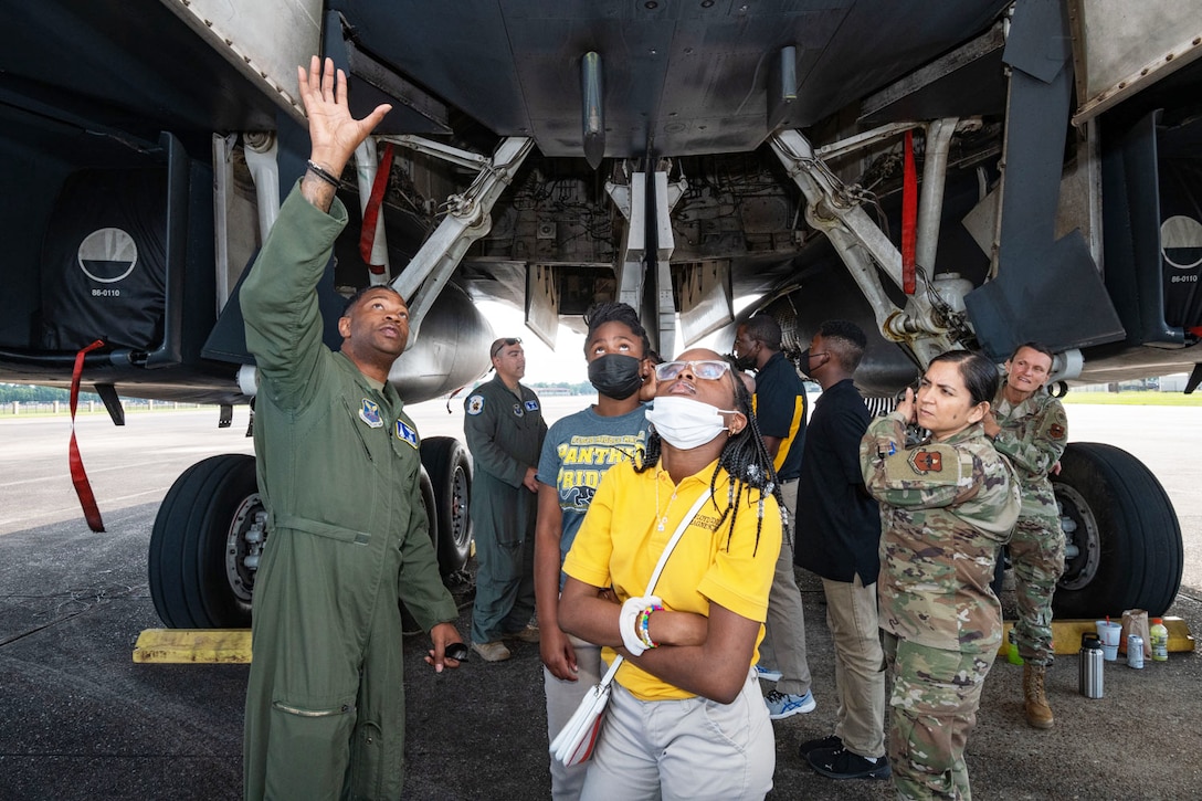 Students look up at the bottom of an aircraft.