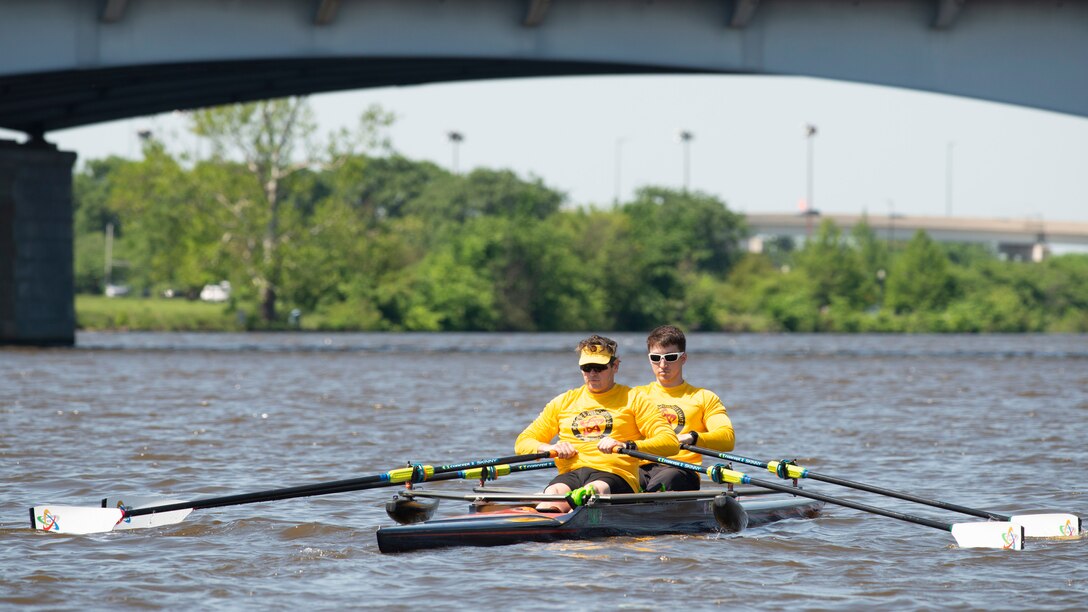 Veteran service member and coach practice rowing.