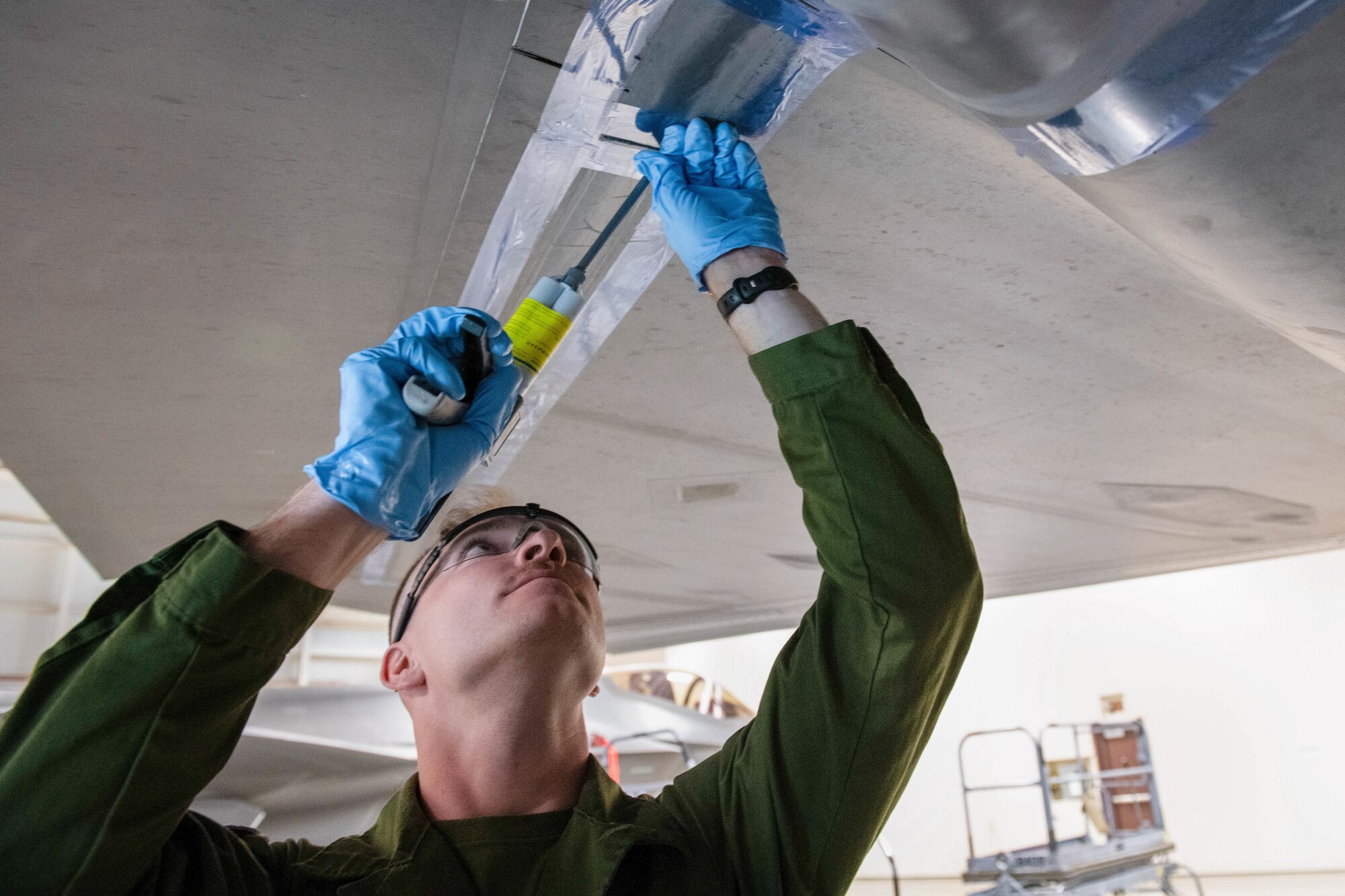 U.S. Marine Corps Sgt. Jared Stevison, Marine Fighter Attack Squadron 214 avionics technician, applies low observable paste to the wing of an F-35A Lightning II aircraft May 9, 2022, at Luke Air Force Base, Arizona.