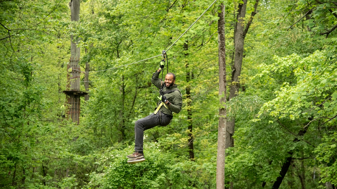 Participant uses zip line to complete course.