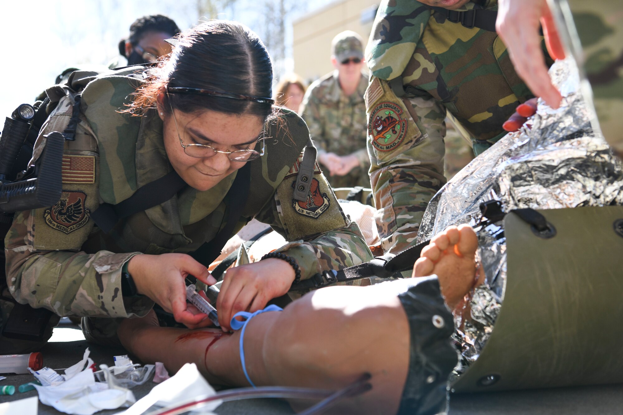 N.Y. Air National Guard 106th Rescue Wing Senior Airman Catalina Garcia-Canas, a 106th combat medic, injects medicine in the arm a “patient,” an advanced medical simulation dummy, at Joint Base Elmendorf-Richardson in Anchorage, Alaska, May 5, 2022. The combat medics of the 106th Medical Group participated in their first Military Facility Annual Training since the start of the COVID-19 pandemic, and were expected to encounter a patient, assess the injuries, mitigate the risk, stop bleeding, treat secondary wounds, and/or resuscitate the patient and maintain the airway. (Air National Guard photo by SSgt Daniel H. Farrell)