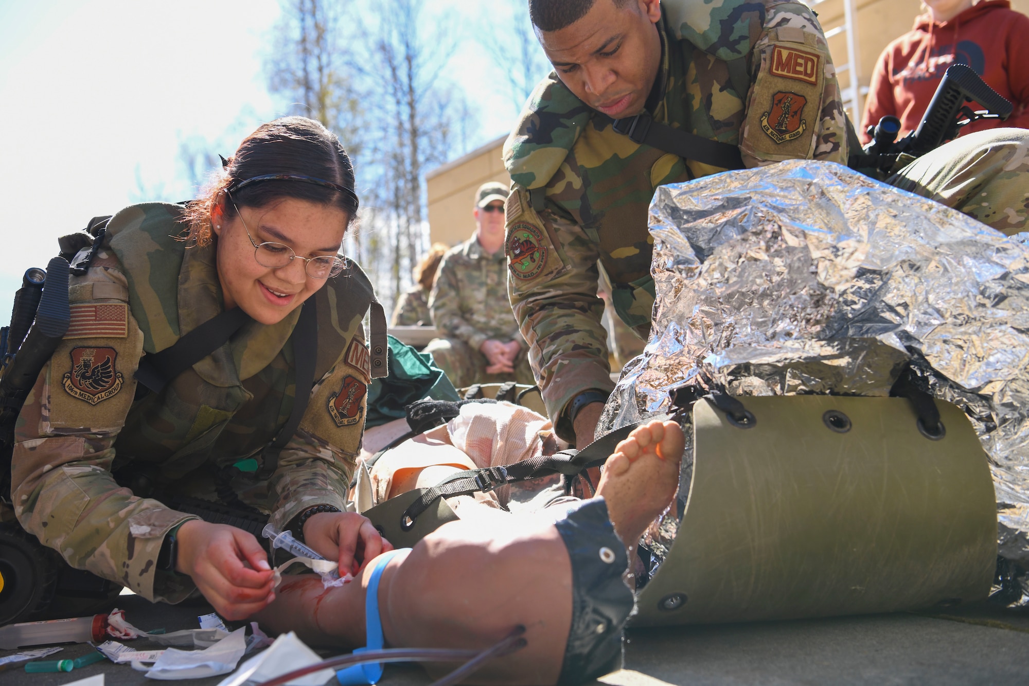 N.Y. Air National Guard 106th Rescue Wing Senior Airman Catalina Garcia-Canas, a 106th combat medic, injects medicine in the arm a “patient,” an advanced medical simulation dummy, at Joint Base Elmendorf-Richardson in Anchorage, Alaska, May 5, 2022. The combat medics of the 106th Medical Group participated in their first Military Facility Annual Training since the start of the COVID-19 pandemic, and were expected to encounter a patient, assess the injuries, mitigate the risk, stop bleeding, treat secondary wounds, and/or resuscitate the patient and maintain the airway. (Air National Guard photo by SSgt Daniel H. Farrell)