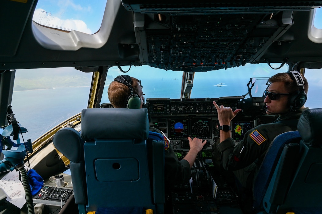 Pilots from the 535th Airlift Squadron fly in a formation with a Royal Australian Air Force and Hawaii Air National Guard C-17 Globemaster III during an aerial maneuver training mission around the Hawaiian islands as part of Exercise Global Dexterity 2022 at Joint Base Pearl Harbor-Hickam, Hawaii, May 3, 2022. The RAAF and USAF conducted joint flying missions alongside each other and swapped aircrew members to better learn of each others’ procedures and techniques. (U.S. Air Force photo by Staff Sgt. Alan Ricker)