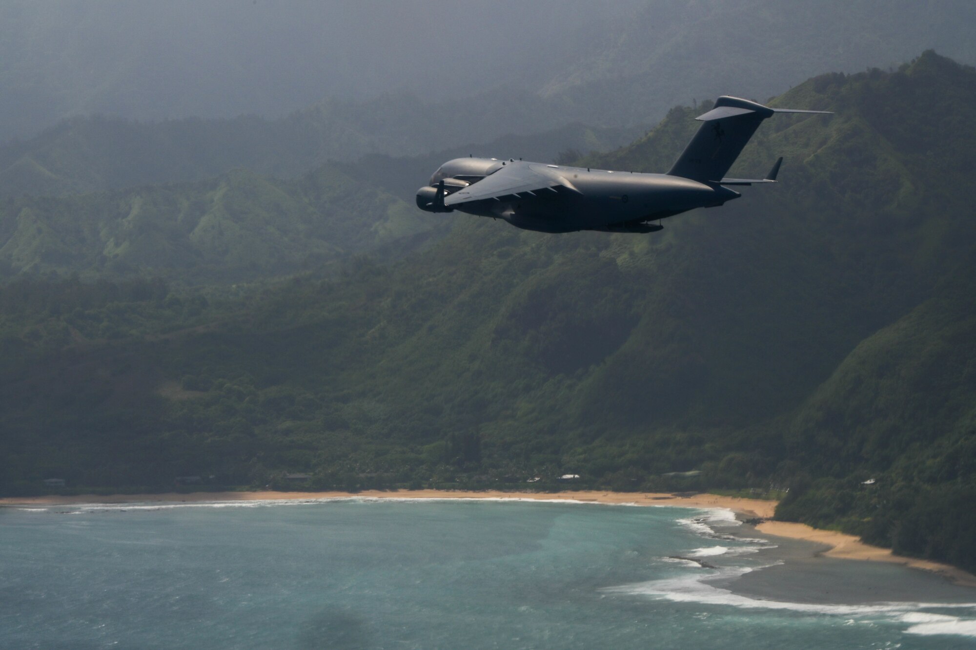 A Royal Australian Air Force C-17 Globemaster III flies in a formation with U.S Air Force C-17s during an aerial maneuver training mission around the Hawaiian Islands as part of Exercise Global Dexterity 2022 at Joint Base Pearl Harbor-Hickam, Hawaii, May 3, 2022. Exercise Global Dexterity 2022 included side-by-side training of C-17s from the USAF, Hawaii Air National Guard, and the RAAF to better develop tactics between the three forces. (U.S. Air Force photo by Staff Sgt. Alan Ricker)