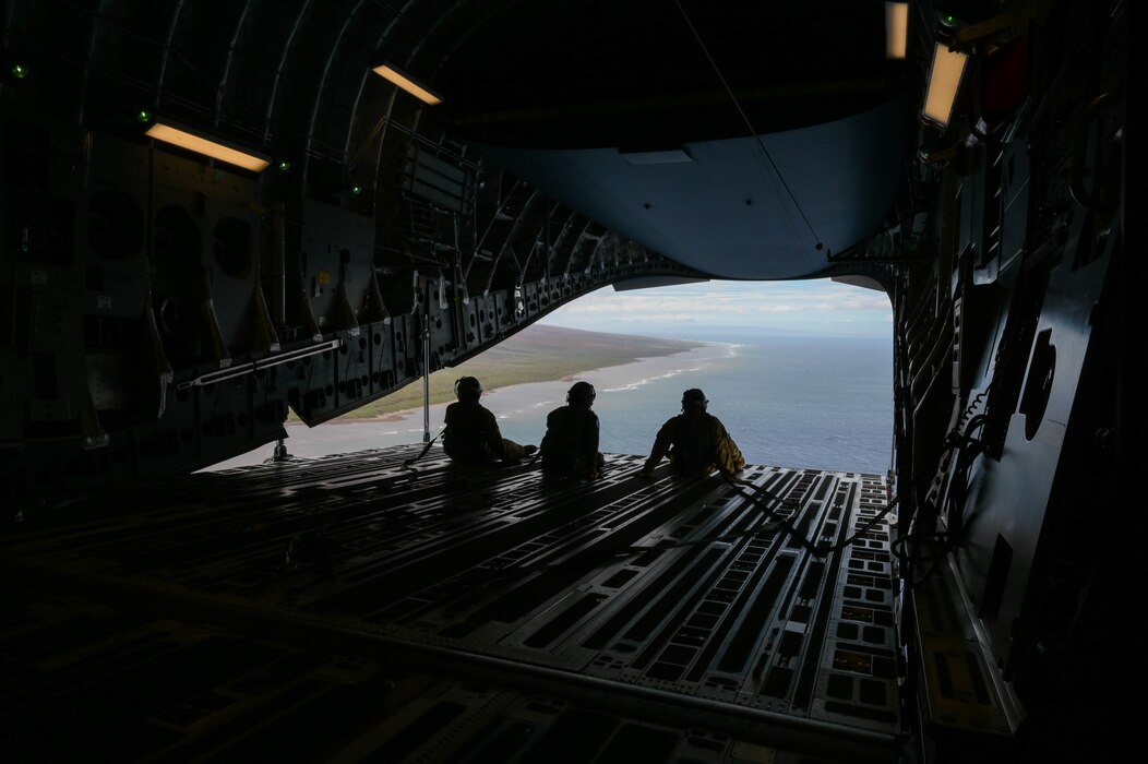 U.S. Air Force loadmasters from the 535th Airlift Squadron and the Royal Australian Air Force No. 36 Squadron sit on the ramp of a C-17 Globemaster III during a training mission around the Hawaiian islands as part of Global Dexterity 2022 at Joint Base Pearl Harbor-Hickam, Hawaii, May 3, 2022. The 15th Wing invited the RAAF No. 36 Squadron to join in a bilateral C-17-focused exercise to better increase interoperability for future Indo-Pacific operations. (U.S. Air Force photo by Staff Sgt. Alan Ricker)