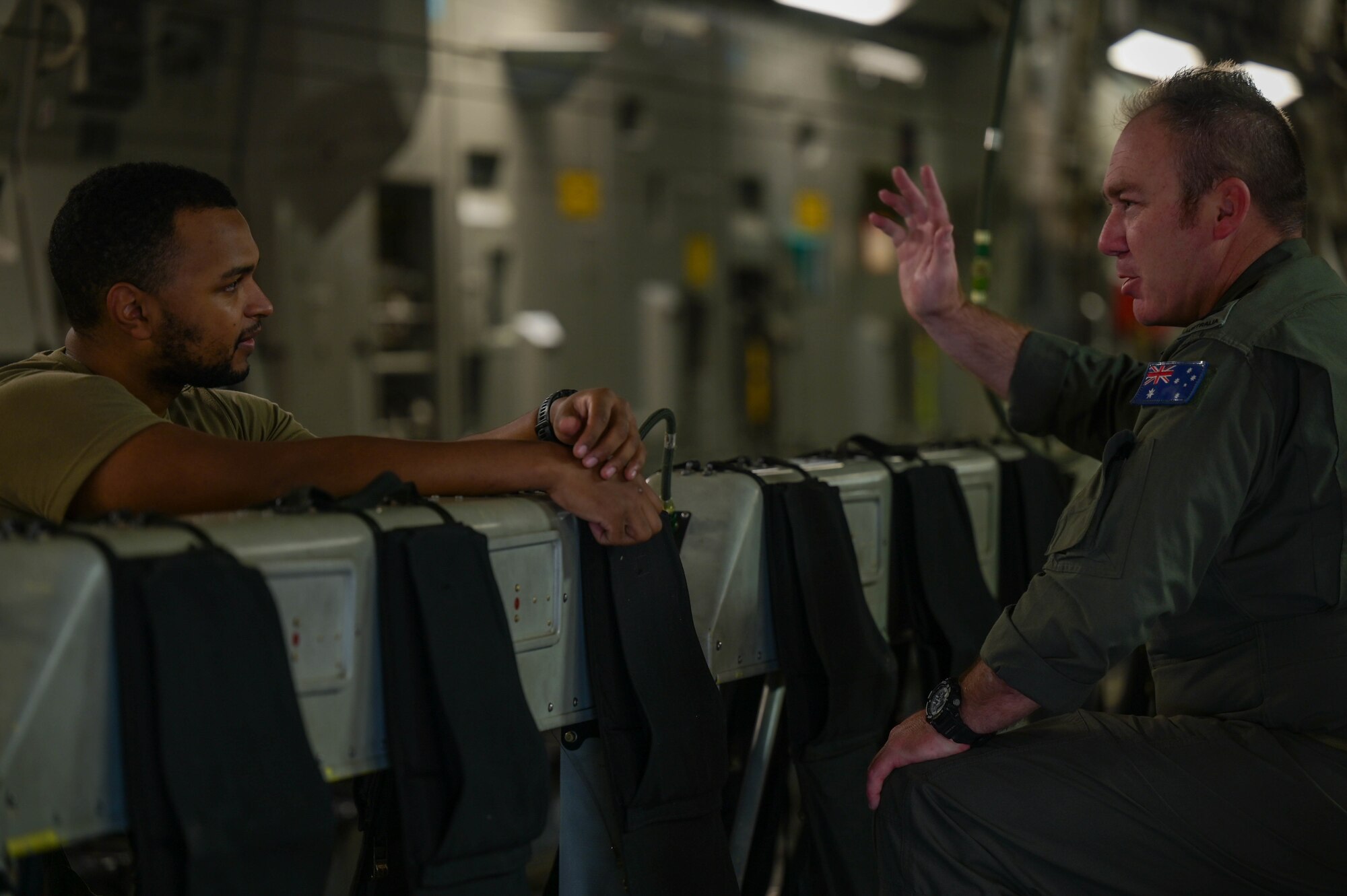 U.S. Air Force Airman 1st Class Kaycee Orns, 535th Airlift Squadron loadmaster, speaks with Royal Australian Air Force Flight Sgt. Ben Russell, No. 36 Squadron loadmaster, during Exercise Global Dexterity 2022 at Joint Base Pearl Harbor-Hickam, Hawaii, May 3, 2022. Exercise Global Dexterity included side-by-side training of C-17s from the U.S. Air Force, Hawaii Air National Guard, and the Royal Australian Air Force to better develop tactics between the three forces. (U.S. Air Force photo by Staff Sgt. Alan Ricker)