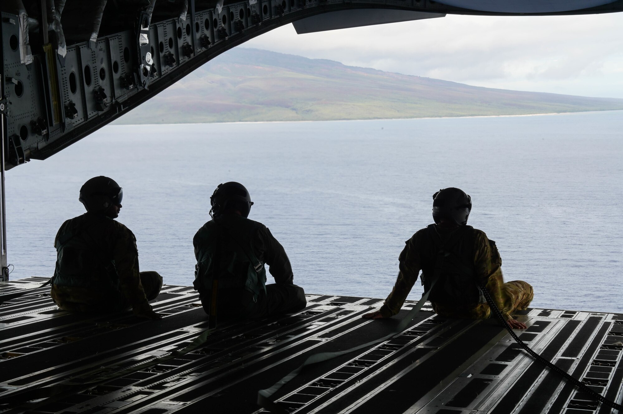 U.S. Air Force loadmasters from the 535th Airlift Squadron and the Royal Australian Air Force No. 36 Squadron sit on the ramp of a C-17 Globemaster III during a training mission around the Hawaiian islands as part of Exercise Global Dexterity 2022 at Joint Base Pearl Harbor-Hickam, Hawaii, May 3, 2022. The 15th Wing invited the RAAF No. 36 Squadron to join in a bilateral C-17-focused exercise to better increase interoperability for future Indo-Pacific operations. (U.S. Air Force photo by Staff Sgt. Alan Ricker)