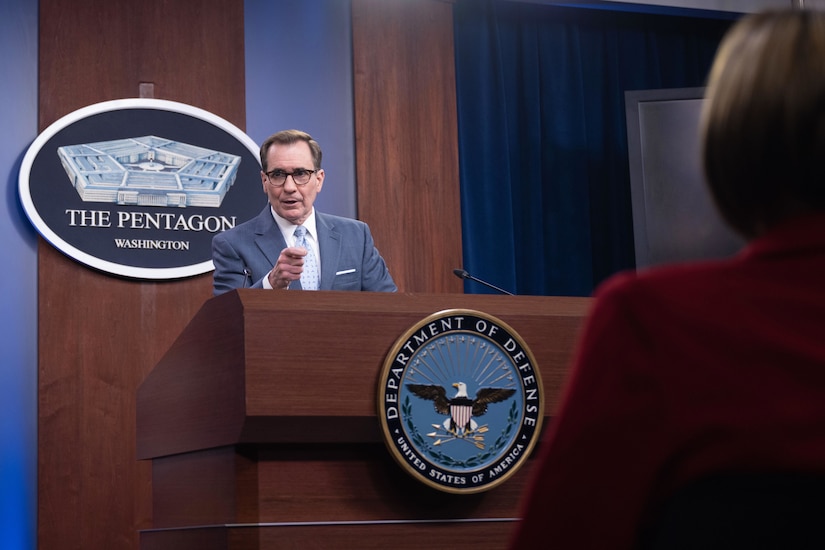 Pentagon Press Secretary John F. Kirby speaks to reporters from a podium.