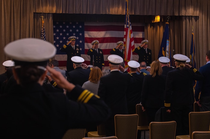 Sailors render honors during the national anthem as part of a change of command ceremony at Naval Base Kitsap-Bangor, Washington May 12, 2022.  During the ceremony, Rear Adm. Mark Sucato relieved Rear Adm. Brad Collins as commander, Navy Region Northwest. (U.S. Navy photo by Mass Communication Specialist 2nd Class Ian Zagrocki)