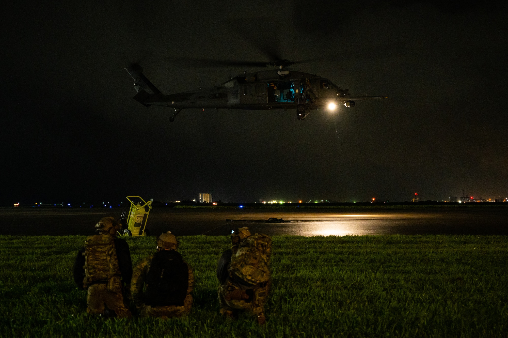 Airmen watch helicopter land.
