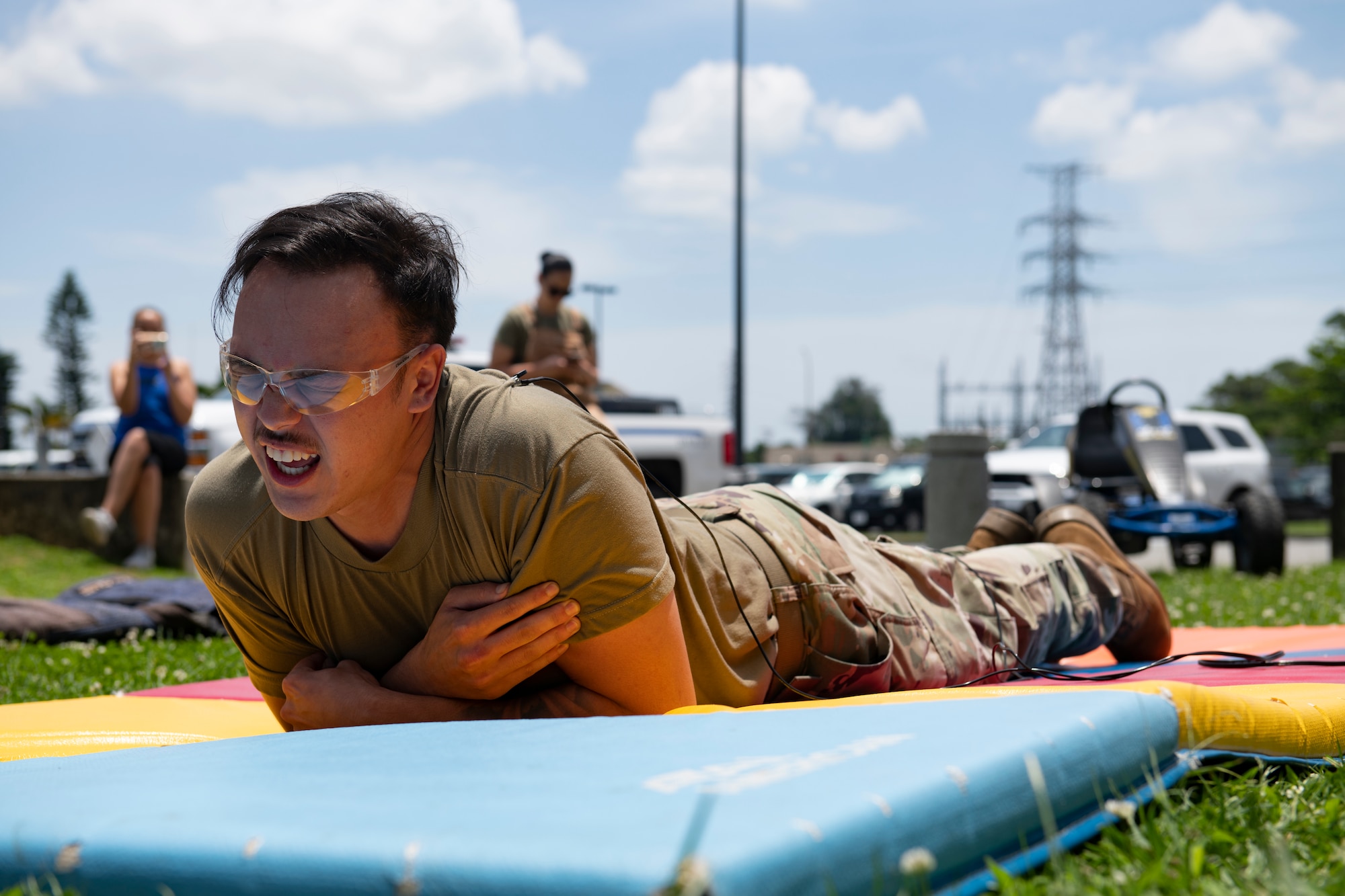 Airman Caleb McIntosh, 18th Logistics Readiness Squadron ground transportation support operator, receives a taser shock during a National Police week demonstration at Kadena Air Base, Japan, May 18, 2022.  Volunteers were able to sign a waiver to feel what it is like to be tasered, an experience every SFS member must have as a part of their training. (U.S. Air Force photo by Senior Airman Jessi Monte)