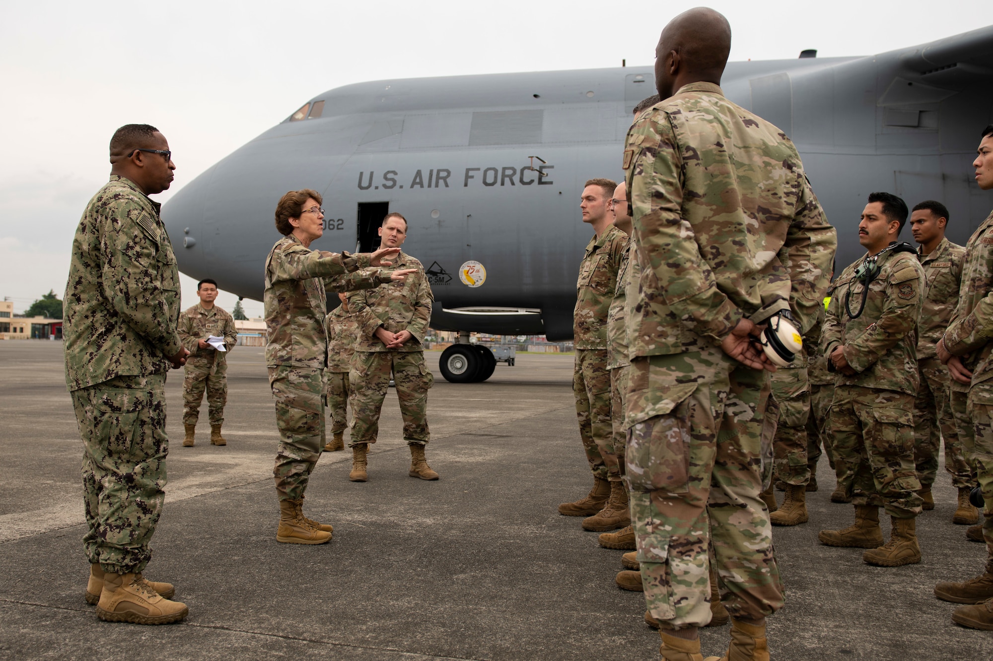 a side view of a female general addressing Airmen assembled in formation, facing her