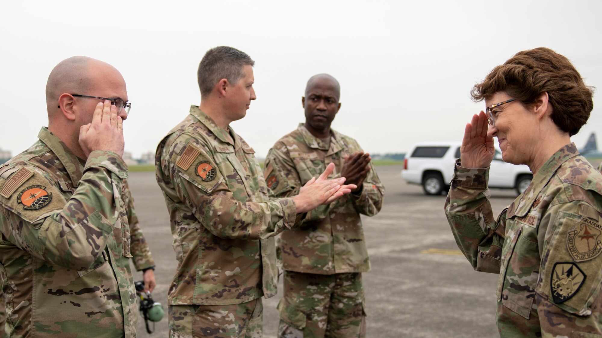 A female general salutes a sergeant on a flight line