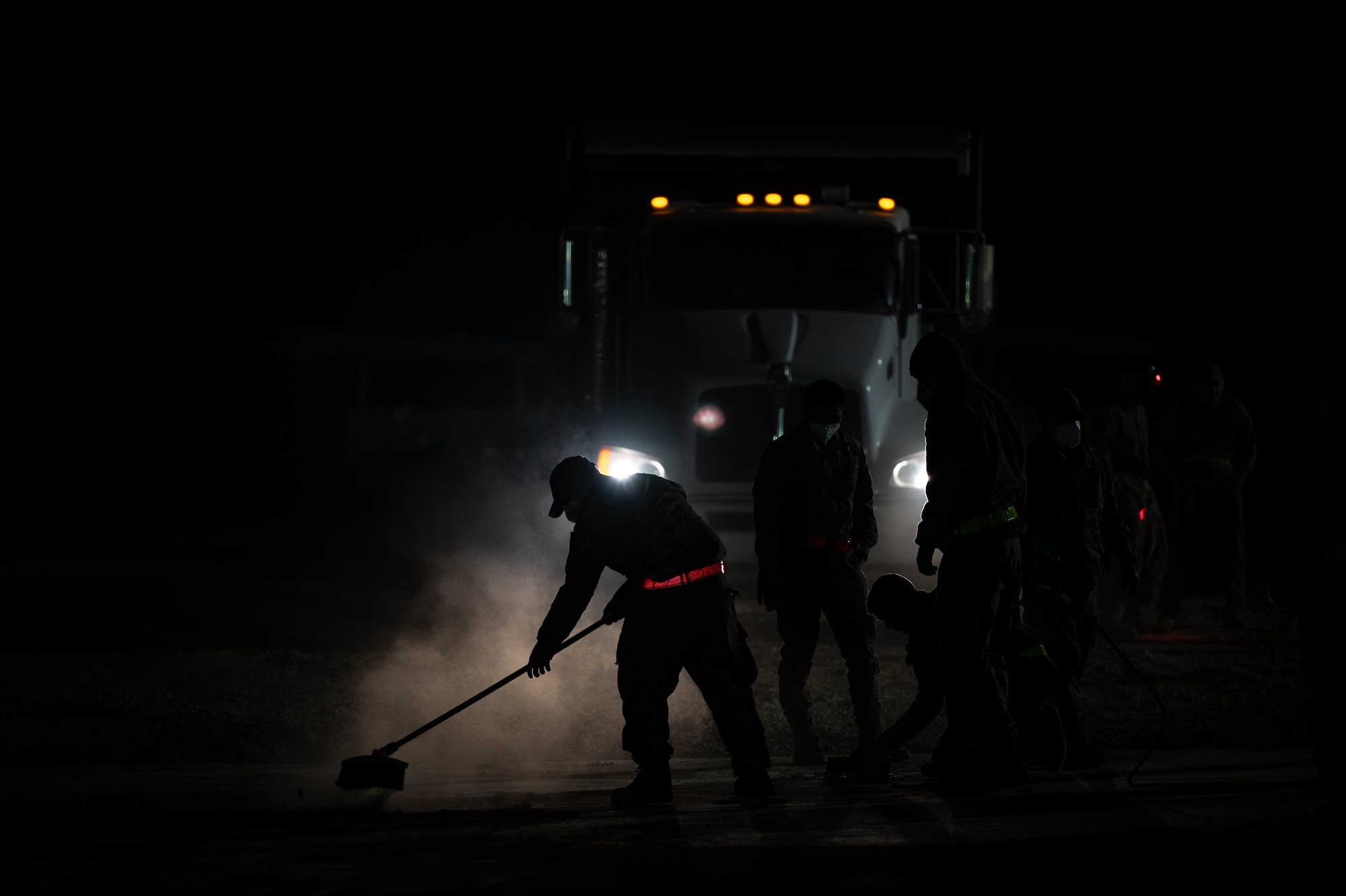 332d Expeditionary Civil Engineer Squadron Airmen clear away debris after a simulated attack on a replicated runway during a rapid airfield damage recovery exercise at an undisclosed location in Southwest Asia, May 12, 2022. RADR exercises test the ability of the 332d ECES to rapidly repair runways and runway support structures to recover and resume airfield operations after it has experienced significant damage. (U.S. Air Force photo by Master Sgt. Christopher Parr)