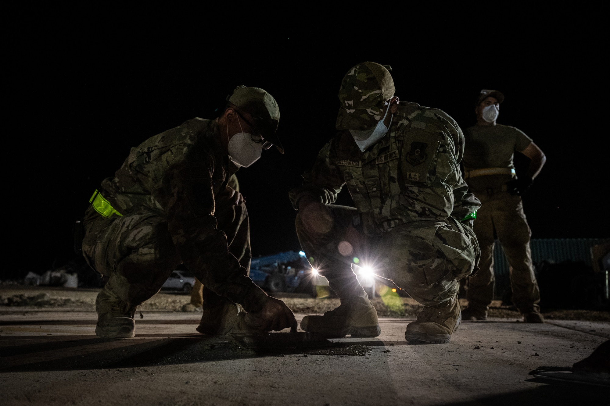 332d Expeditionary Civil Engineer Squadron Airmen expedite the repair of spalls with rapid-setting cement mix during a rapid airfield damage recovery exercise at an undisclosed location in Southwest Asia, May 12, 2022. RADR exercises test the ability of the 332d ECES to rapidly repair runways and runway support structures to recover and resume airfield operations after it has experienced significant damage. (U.S. Air Force photo by Master Sgt. Christopher Parr)