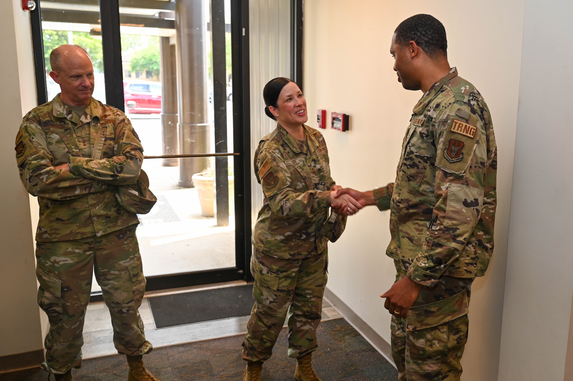 three people stand in a foyer