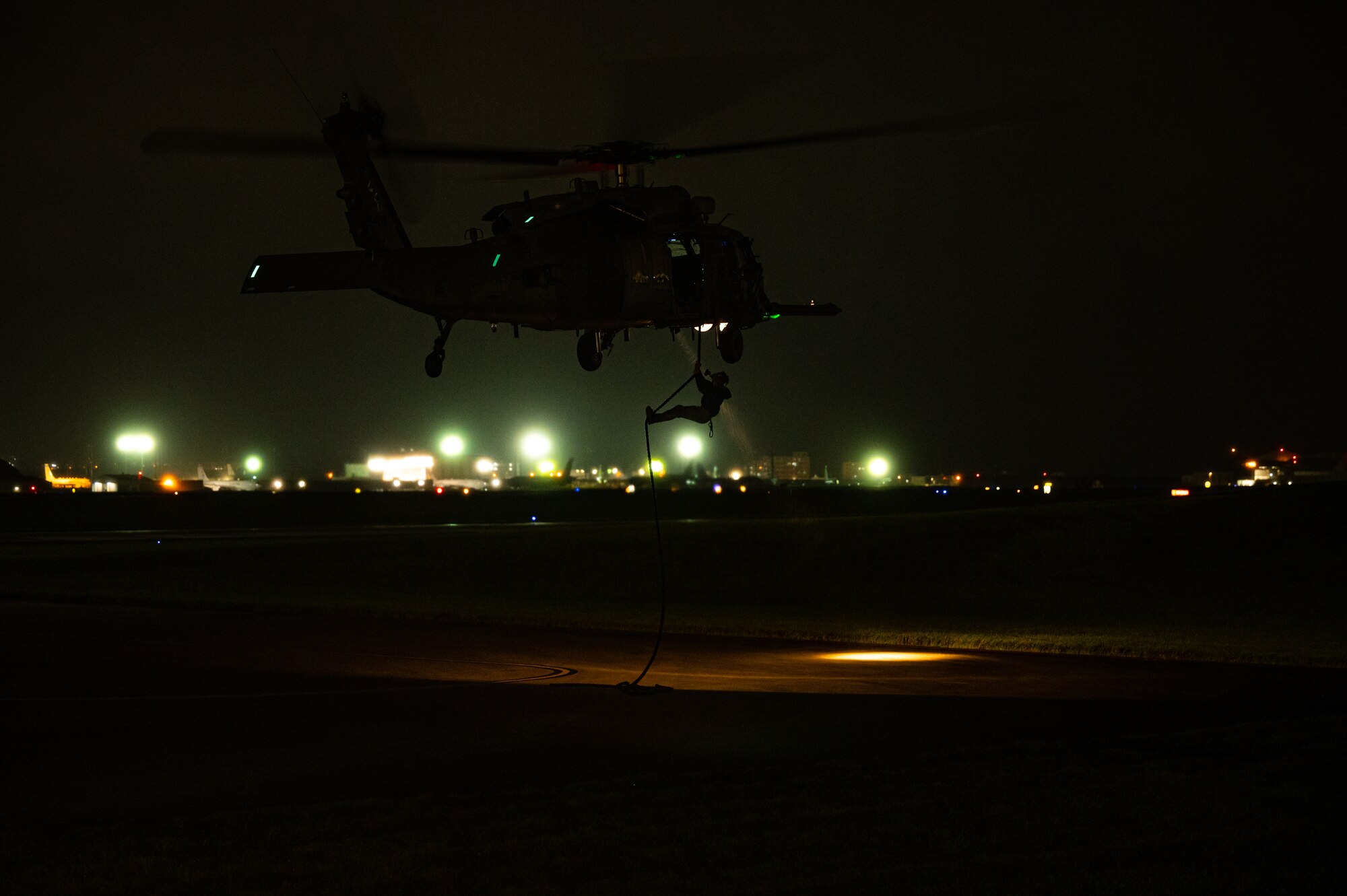 Airman fast-ropes out of helicopter.