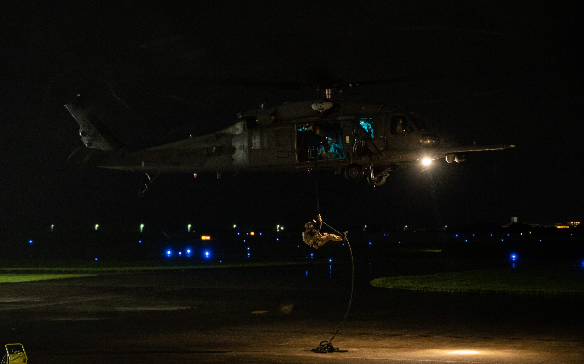 Airman fast-ropes out of helicopter.
