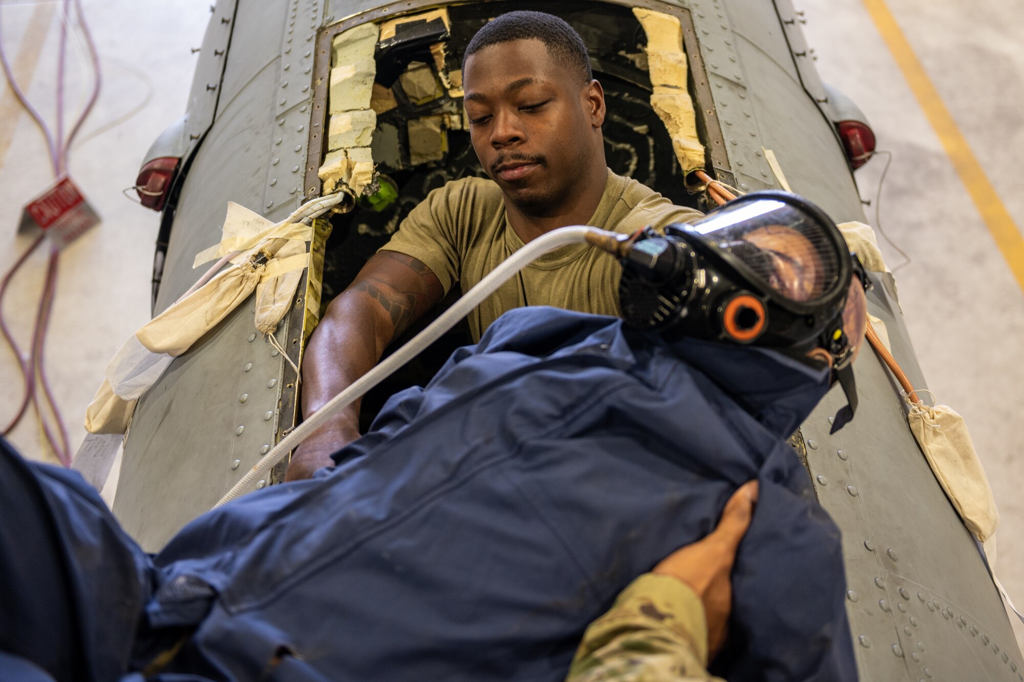 Staff Sgt. Jonathan Ferguson, 51st Maintenance Squadron aircraft fuels systems technician, moves a dummy into place inside the fuel tank compartment of an A-10c Thunderbolt during an annual confined space training and safety event