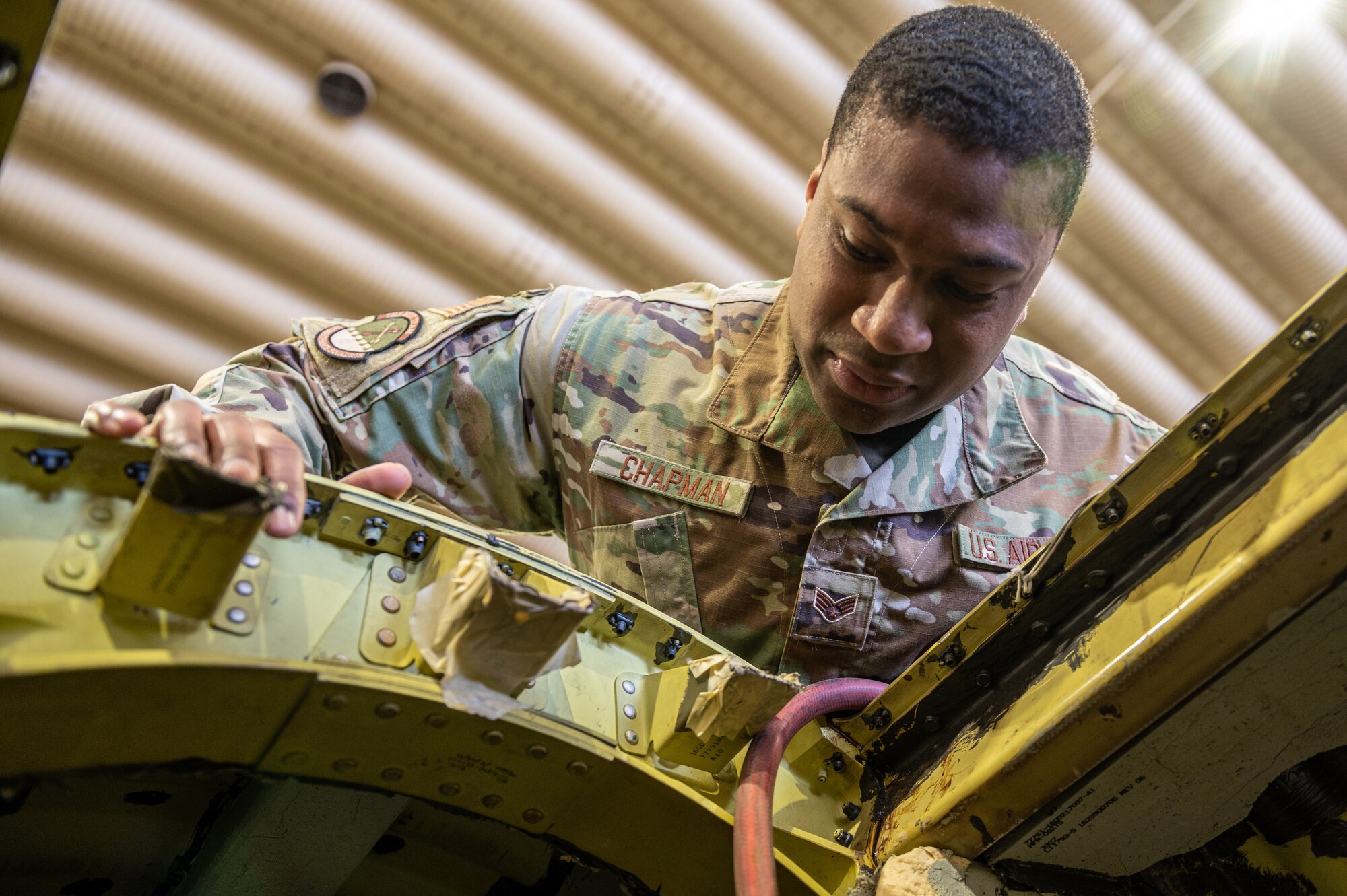 Senior Airman Jeffrey Chapman, Jr., 51st Maintenance Squadron aircraft fuels systems technician, peers into fuel tank compartment of an A-10c Thunderbolt during a confined space training and safety event