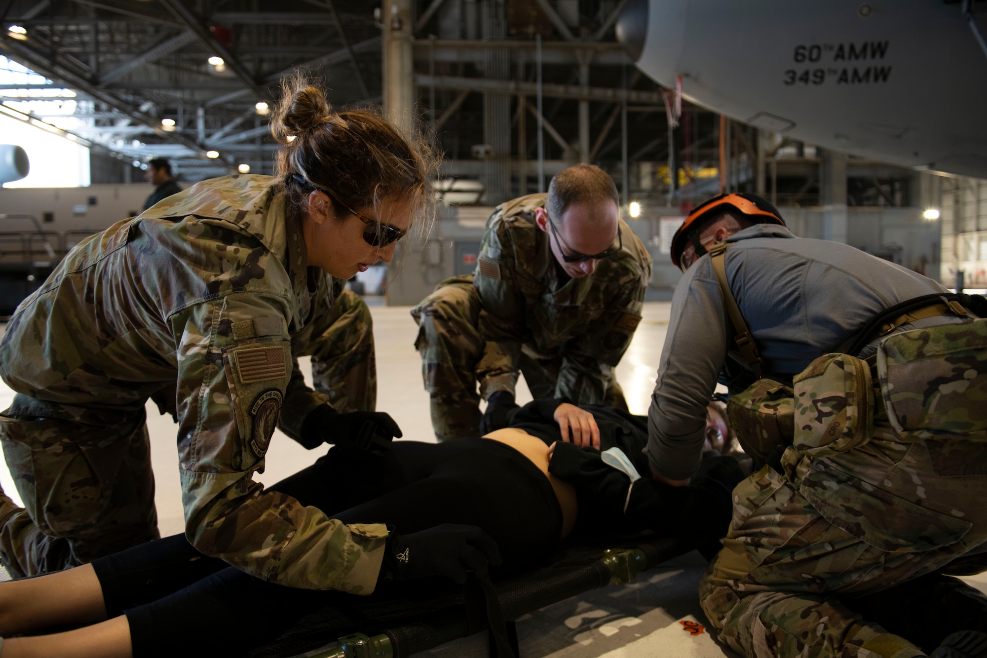 Airmen conduct simulated medical procedures on a simulated patient.