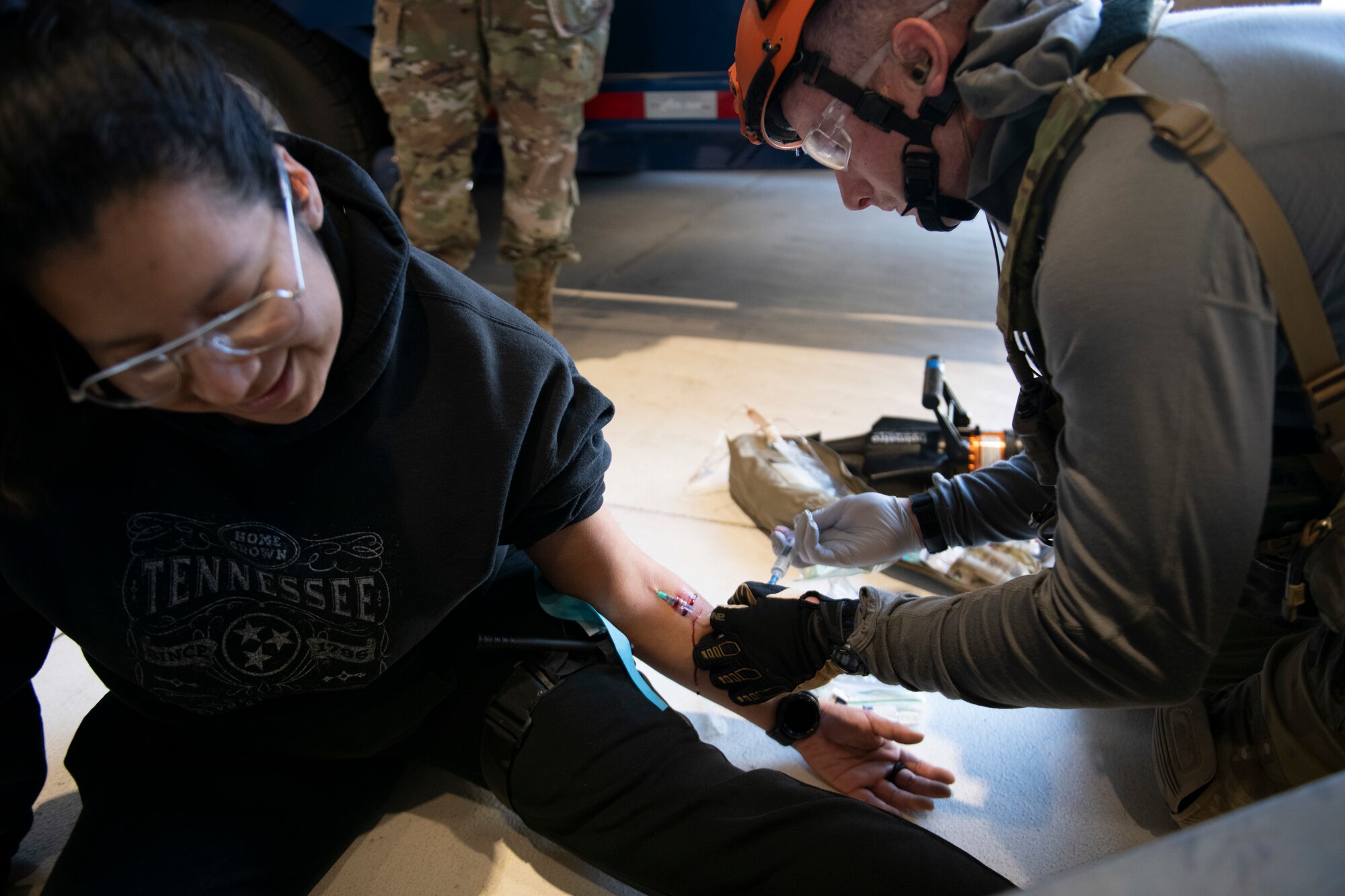 U.S. Air Force Staff Sgt. Kyle Olson, 131st Rescue Squadron pararescueman, inserts an intravenous needle into a simulated casualty while in a hangar during a mass casualty exercise at Travis Air Force Base, California, May 17, 2022.