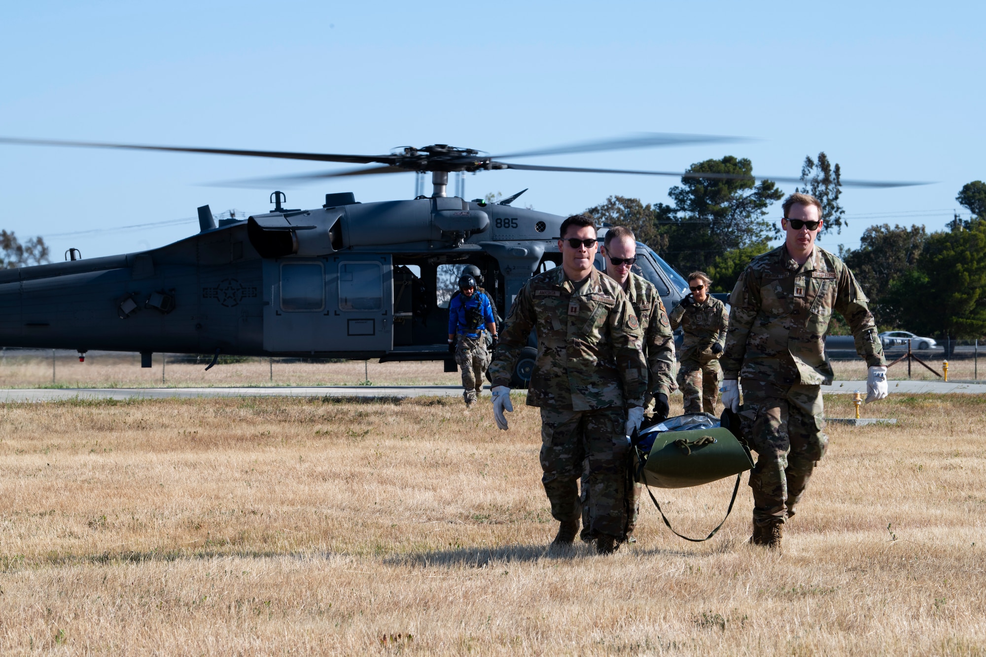 Airmen carry a stretcher.