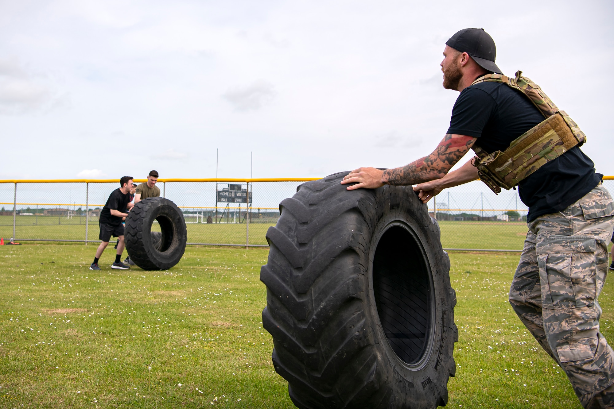 Airmen from the 423d Security Forces Squadron flip tires as part of a defender challenge at RAF Alconbury, England, May 18, 2022. Airmen, civilians and local law enforcement participated in the challenge, held in honor of National Police Week, to pay homage to those who gave their lives in the line of duty. (U.S. Air Force photo by Staff Sgt. Eugene Oliver)